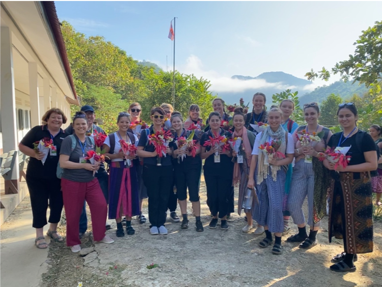 students receive floral blessing from villagers in laos.png