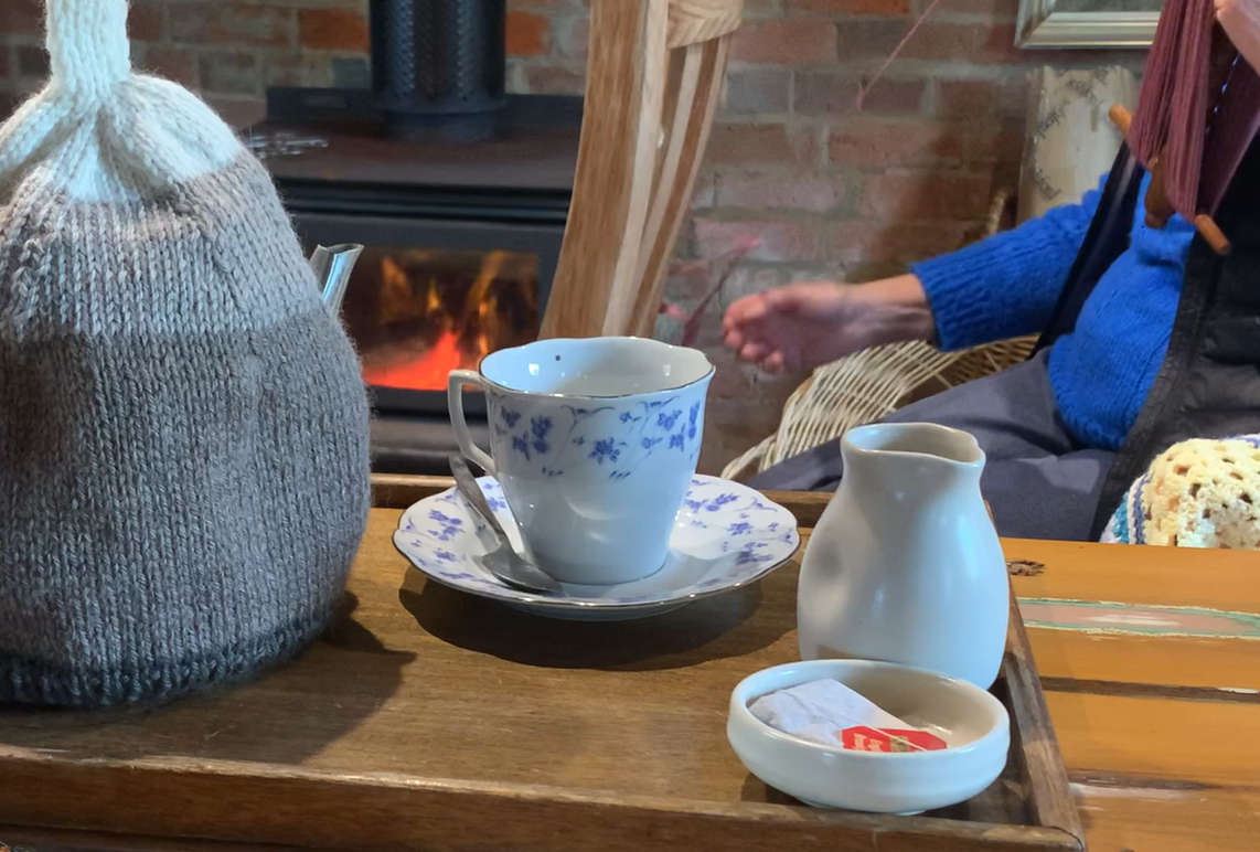 cup of tea in front of fire.png