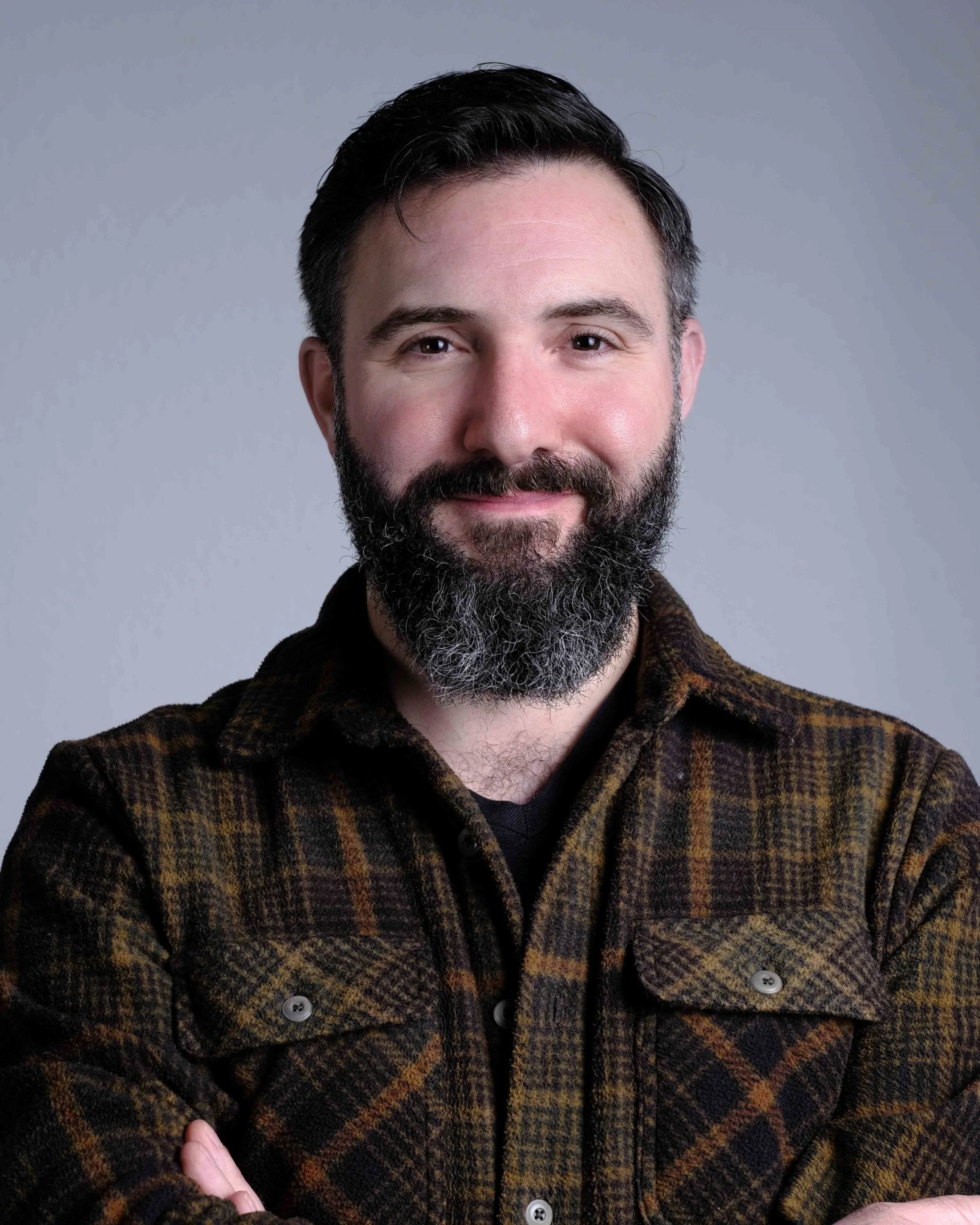 Thomas Florio with beard and flannel shirt looking directly into the camera