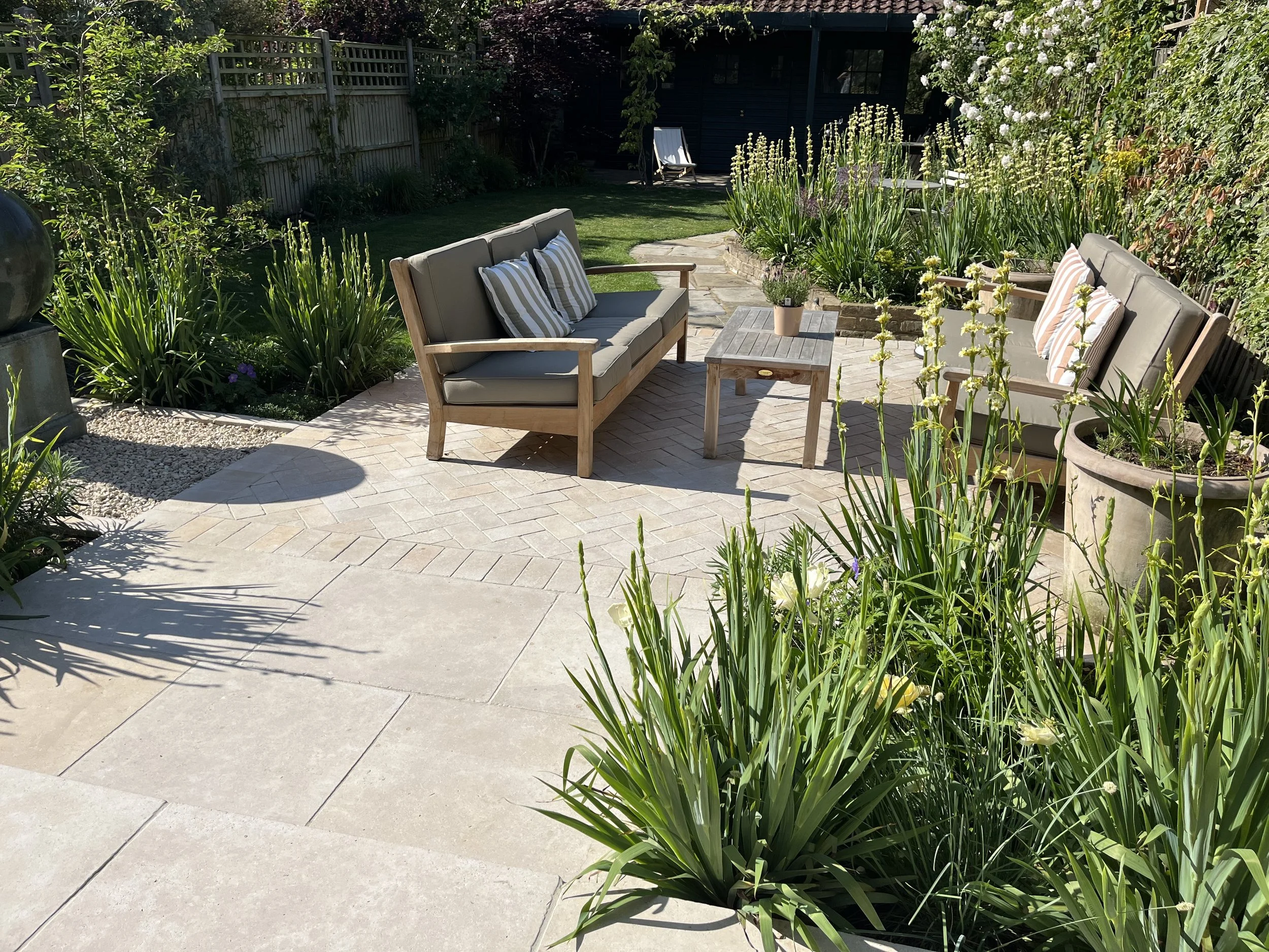 Outdoor lounge enclosed by soft plants