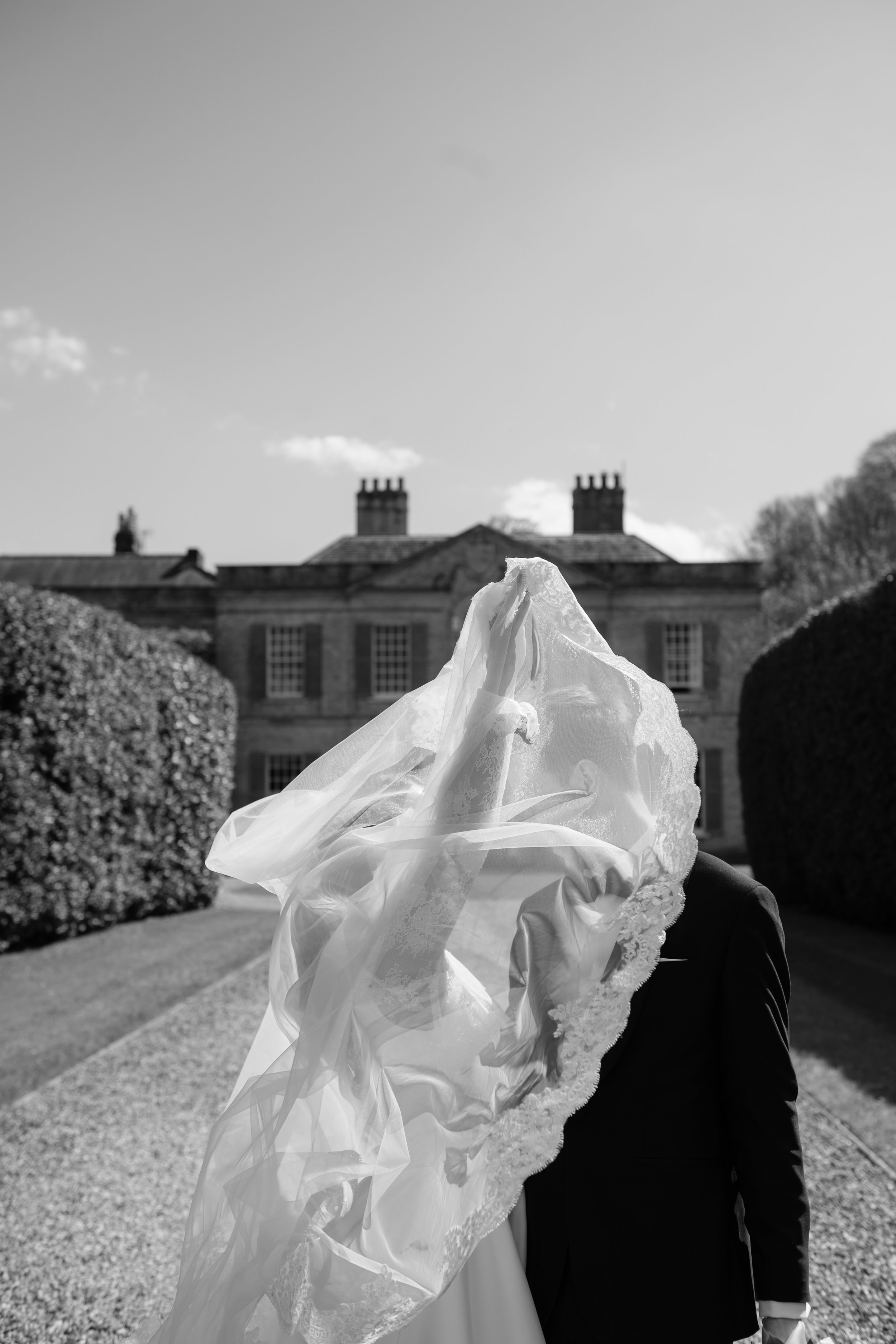 black and white image of a veil getting taken on the wind
