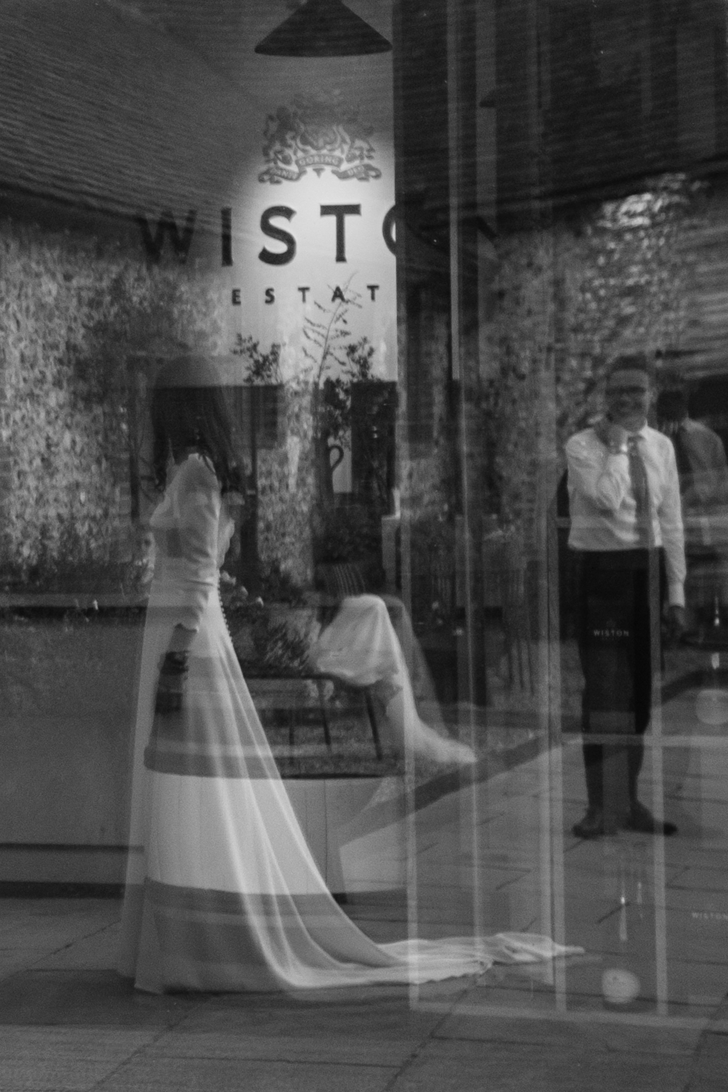 Black and white photo of a reflection of a bride and groom at a wine estate