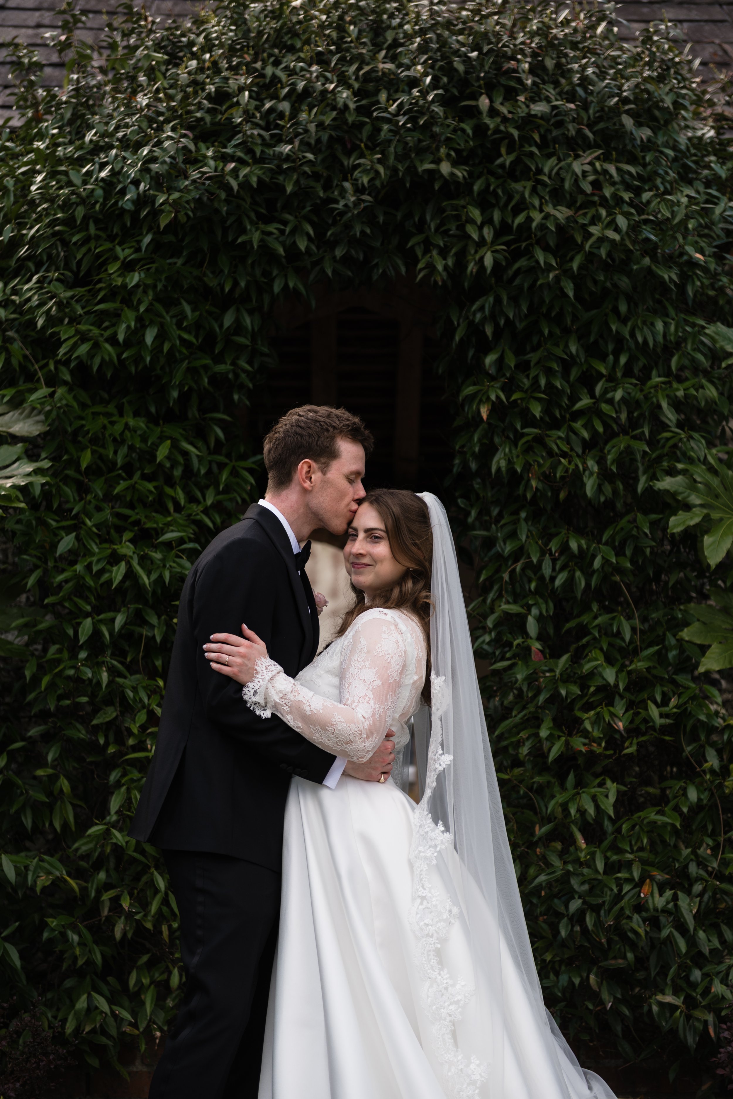 bride and groom against a jasmine arch