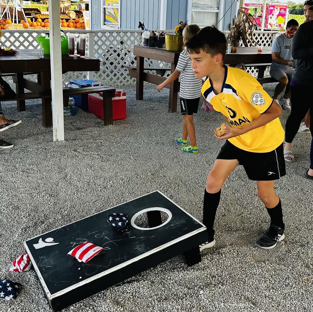 Students of Educational Pathways Academy, school for dyslexia in Florida, play cornhole at PTO Scholarship Fundraiser for Families with Financial Need at Farmer Mike's U Pick.jpg