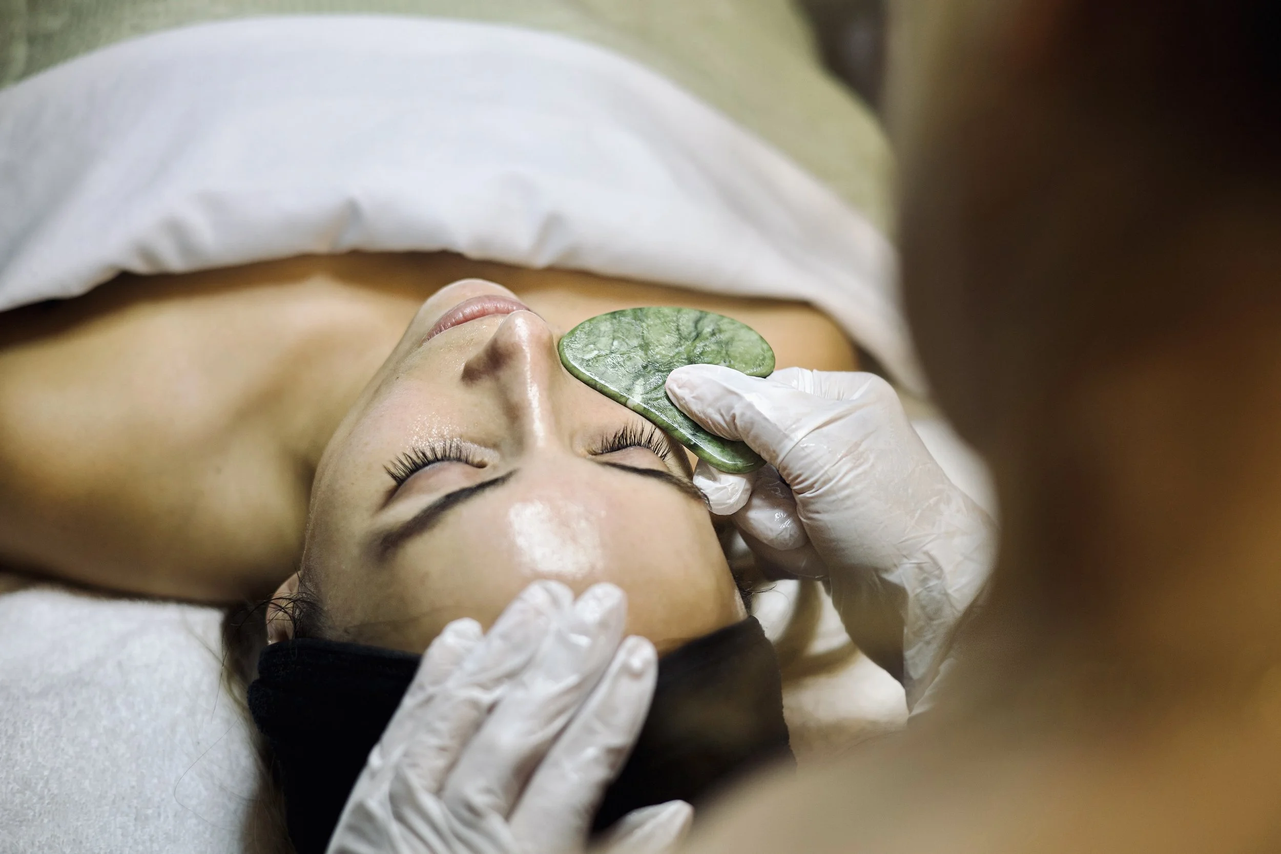 Guasha being used during custom facial