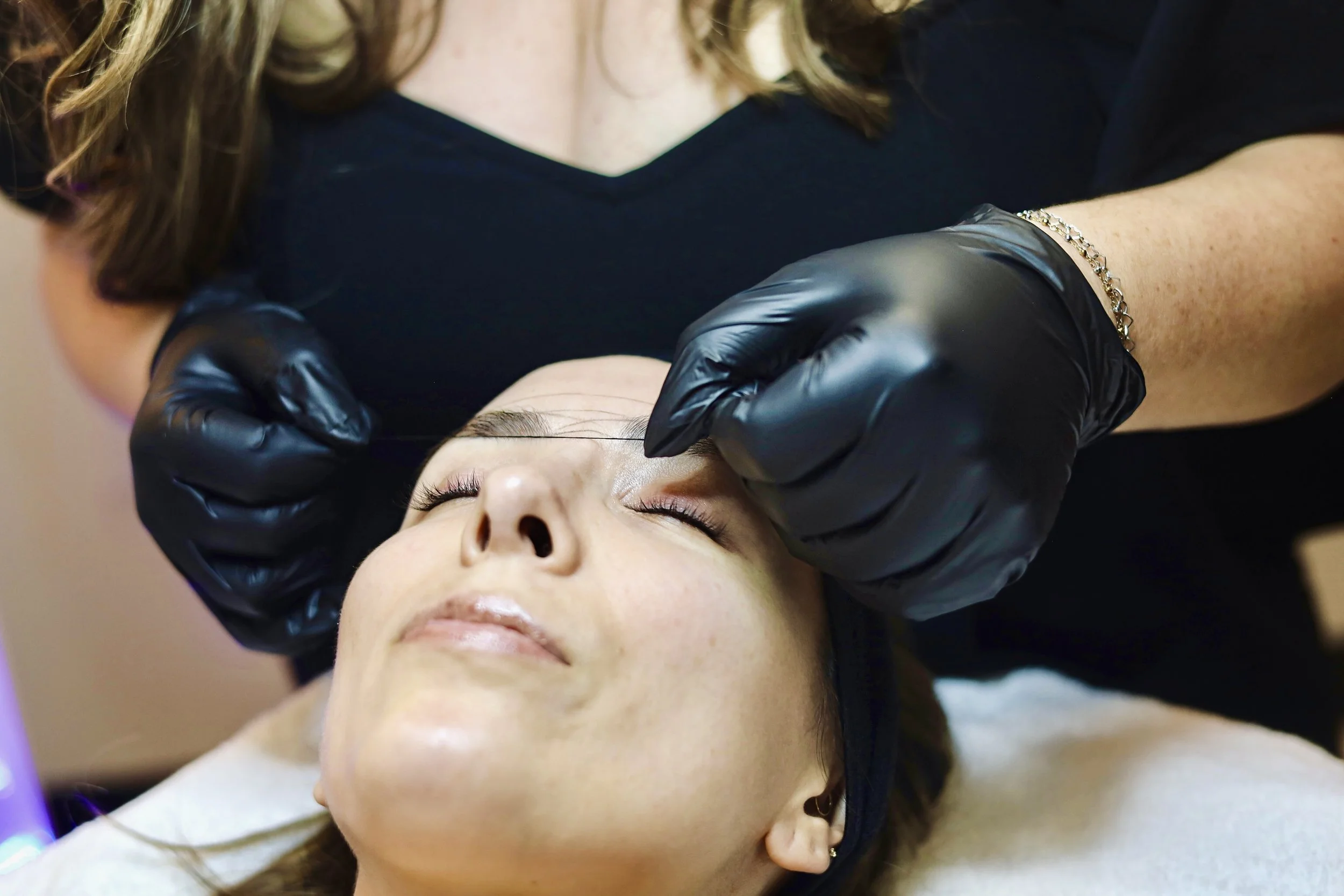 Client's eyebrows being mapped before wax