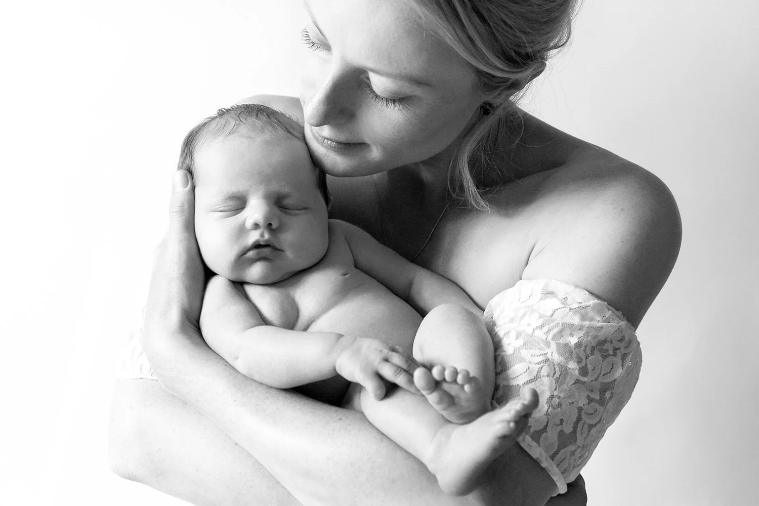 mum holding a baby during a relaxed newborn photoshoot in Cheltenham, Cotswolds