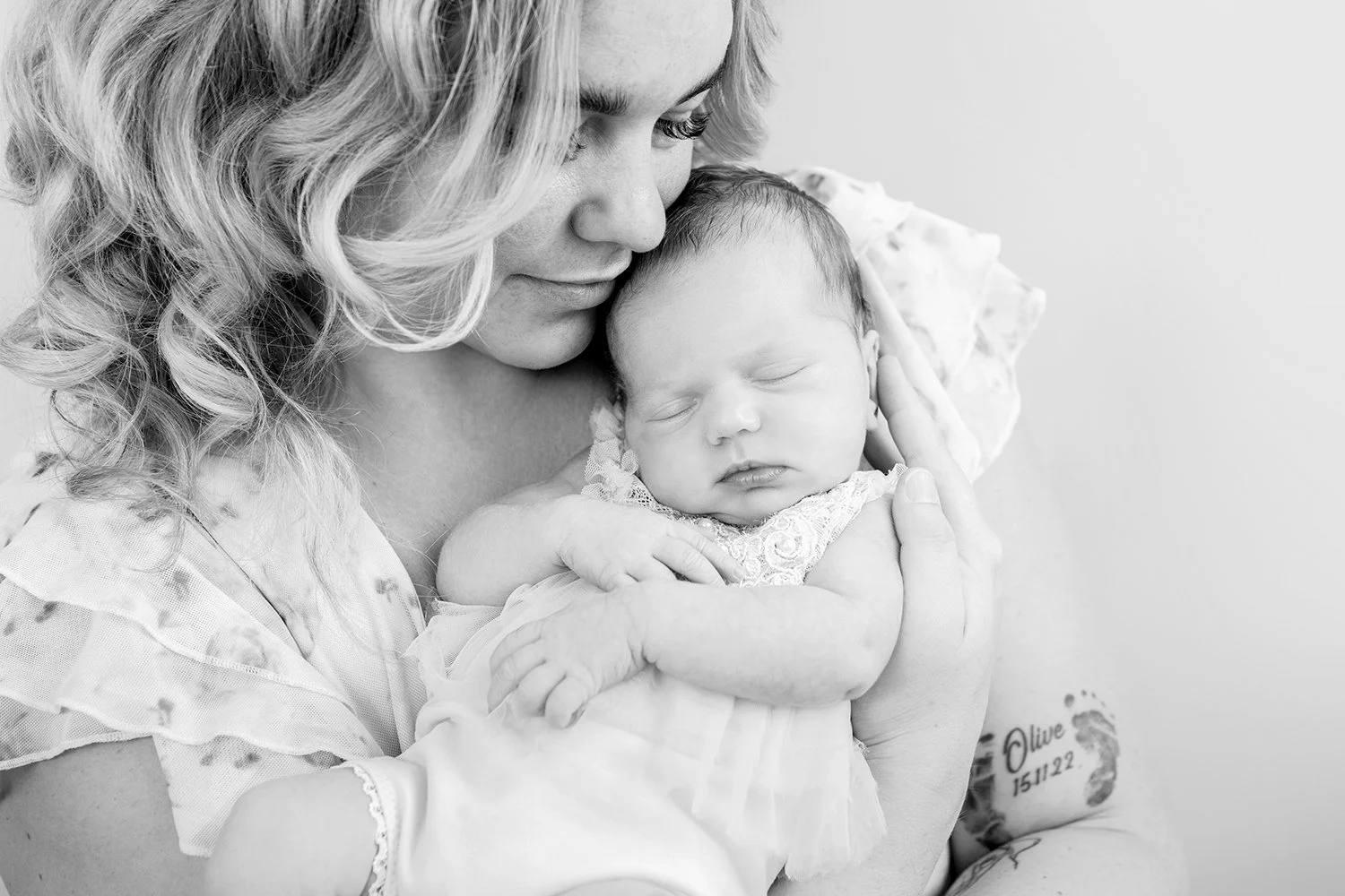mum cuddling her newborn baby during a relaxed in-home family photoshoot in Cheltenham Gloucestershire