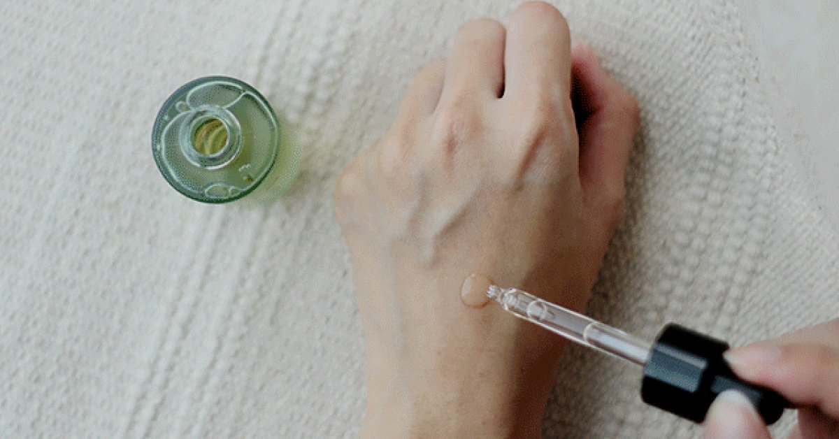 A dropper of Belif product on top of a hand