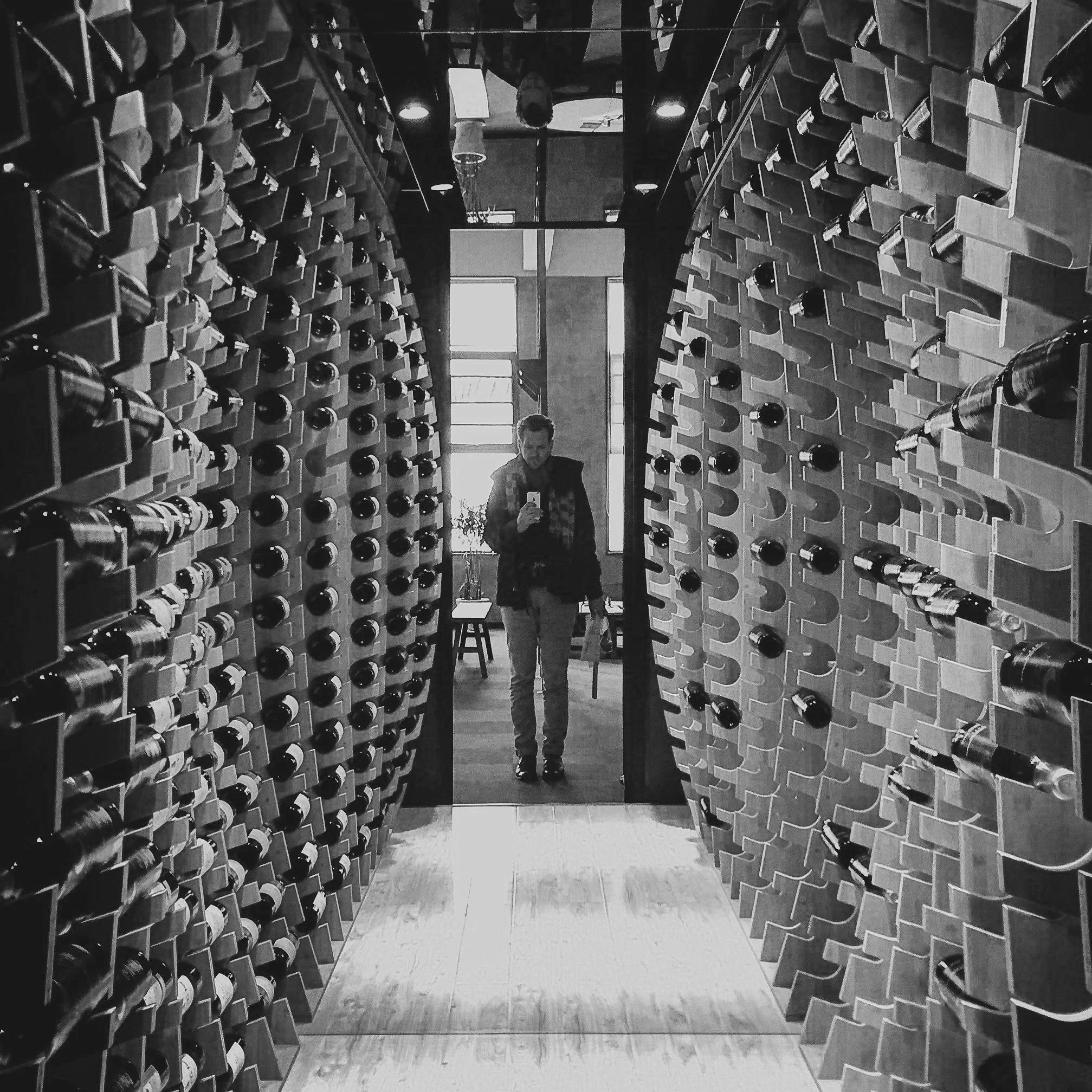 Rows of wine bottles stored on wooden wine racks.
