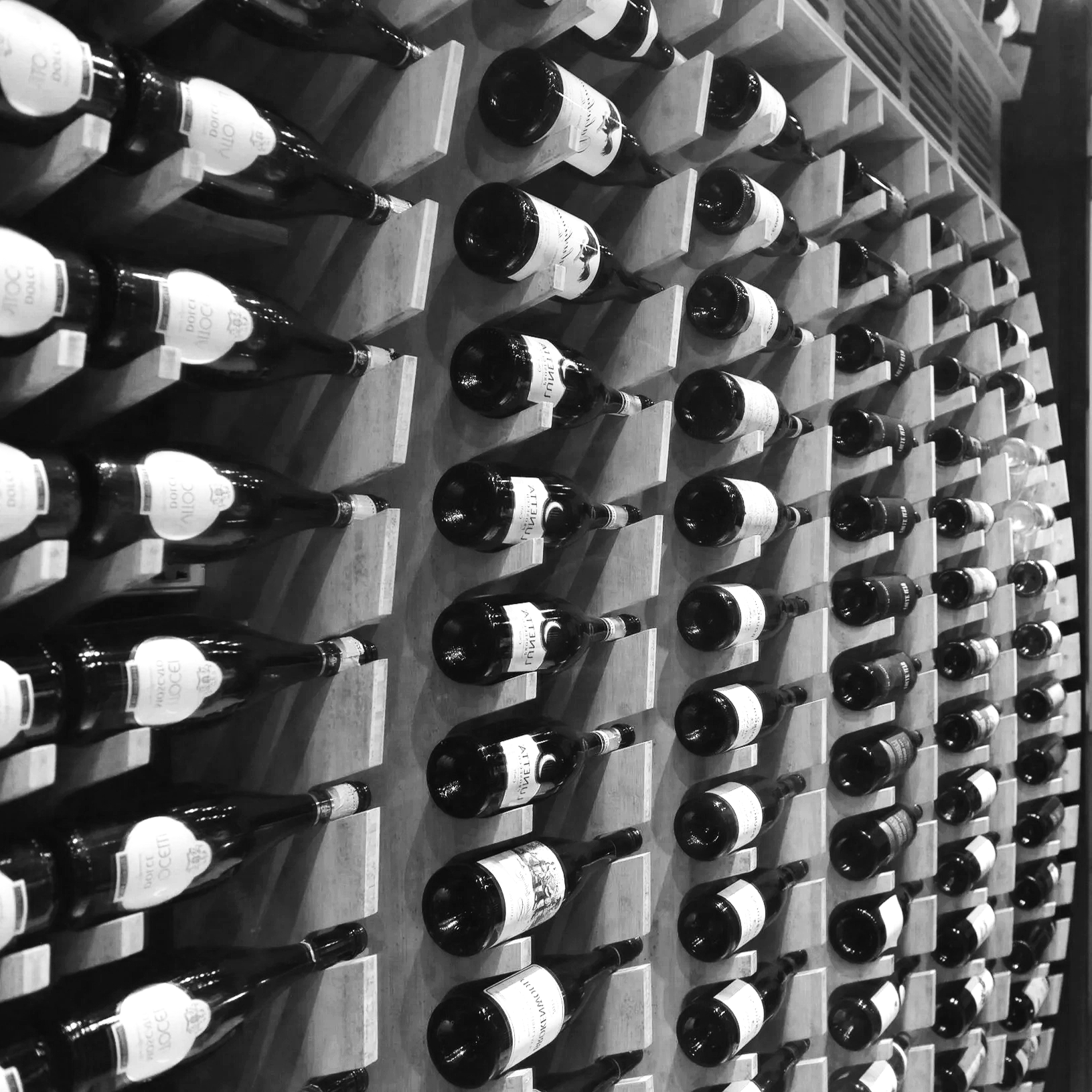 Rows of wine bottles stored on wooden wine racks.