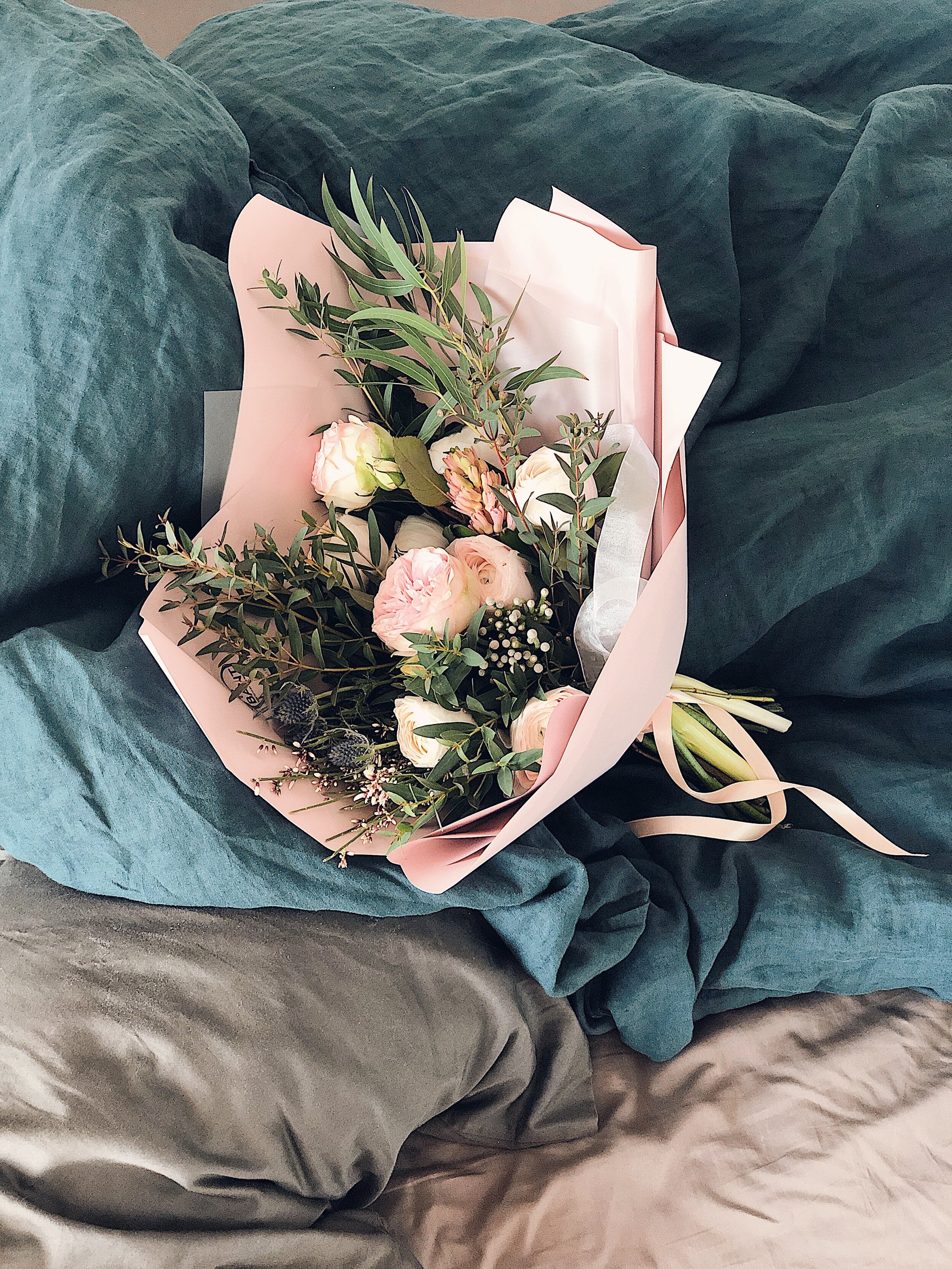 pink-and-green-flower-bouquet-on-bed-sheet-929976.jpg