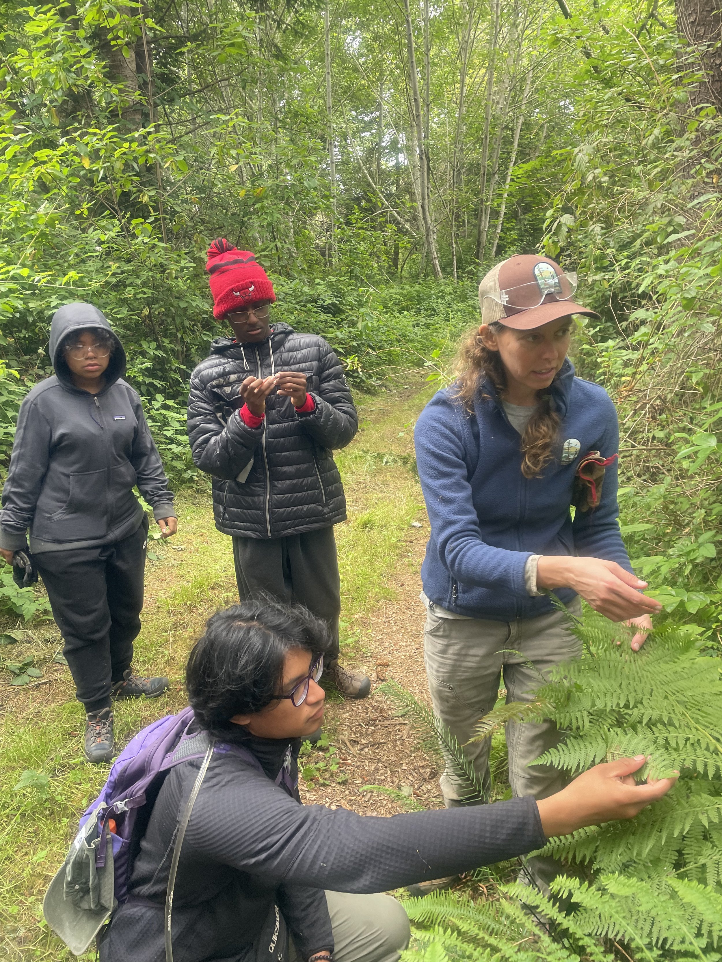  Wildlands Conservancy staff discuss methods for thinning the forest to improve health as they share the names of native plants. Photo: Dulce Real 