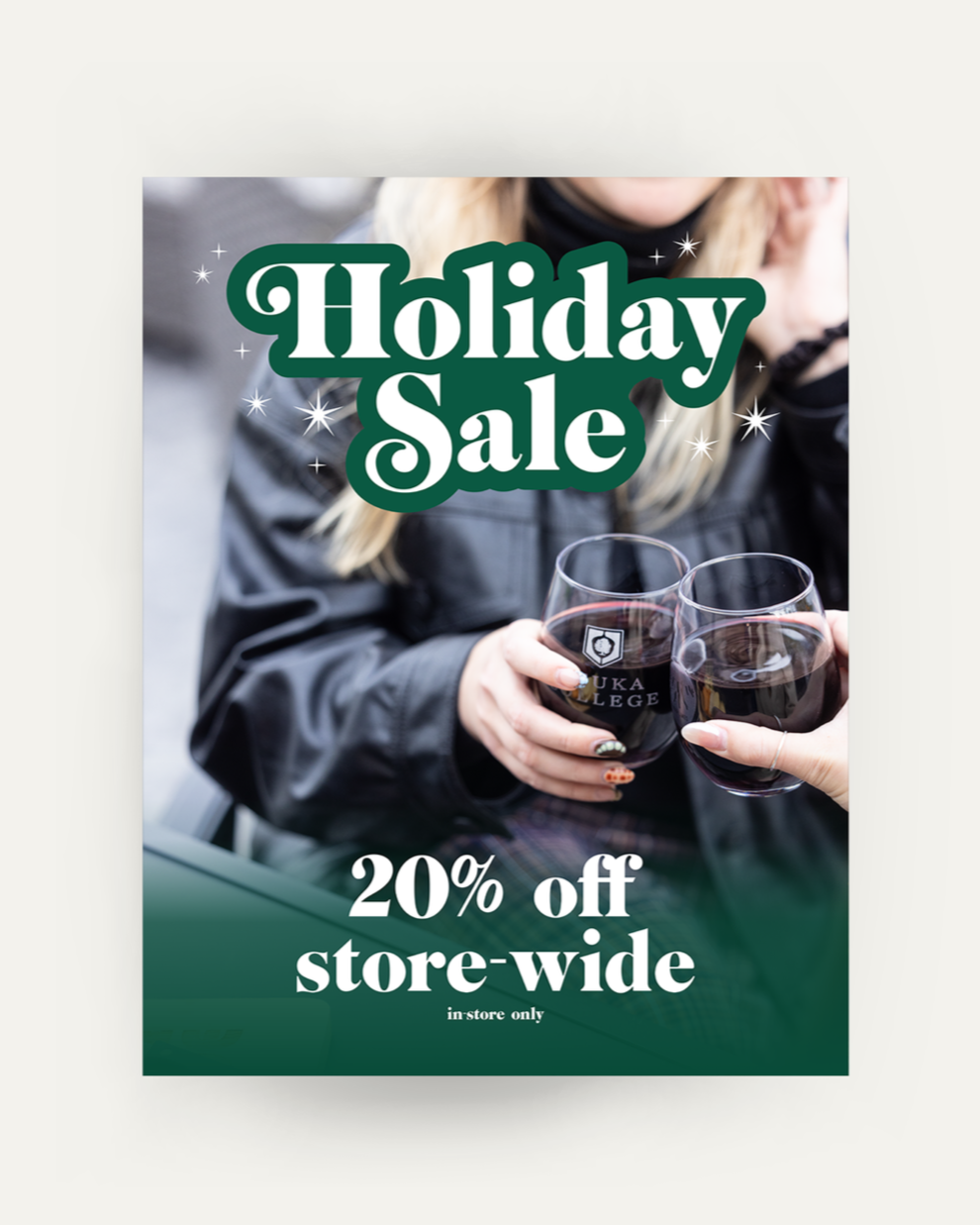 Poster advertising the holiday sale of 20% off store-wide, in-store only, sale ends January 1st 2026. It shows 2 girls holding Keuka College wine glasses.