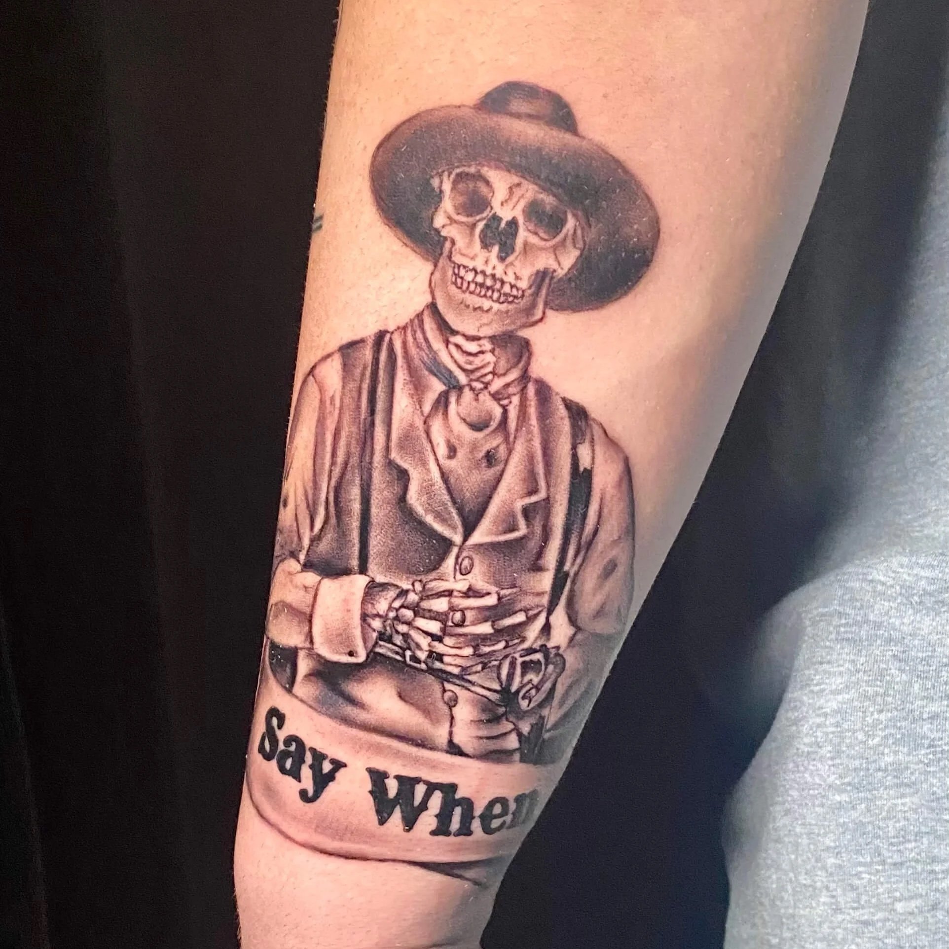 A black and gray realism tattoo of a skeleton Doc Holiday from the Tombstone movie. It was done by Erin Peterson. 