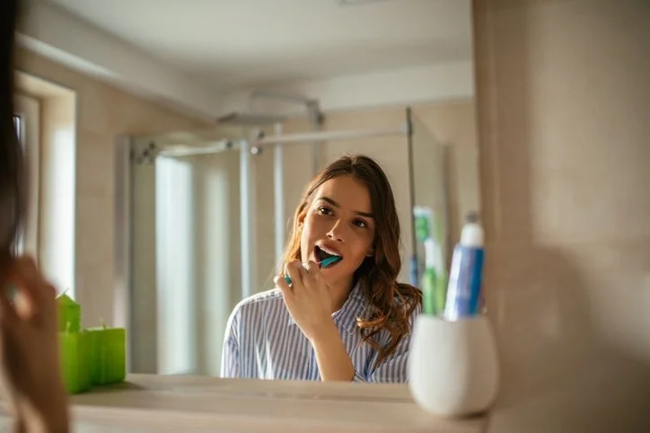 a woman brushing her teeth after dental checkup in winter park