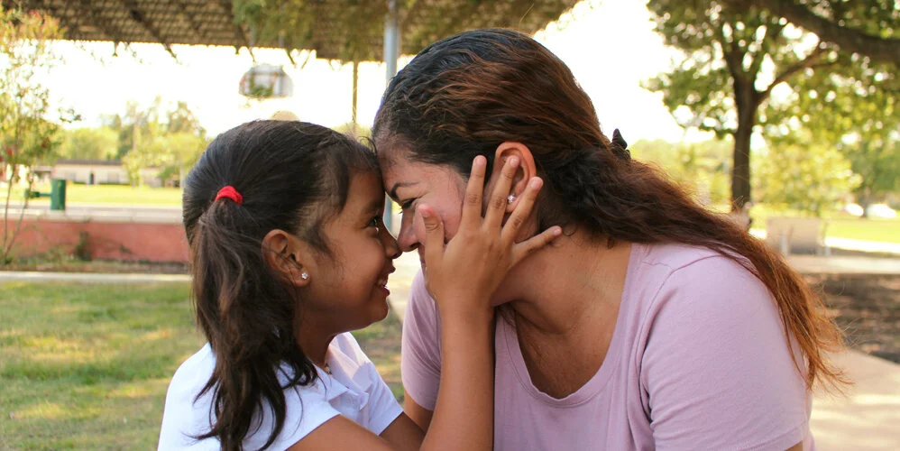 Alisson Ximena Valencia Madrid and her mother Cindy Alinette Madrid Henriquez face each other and touch foreheads in August 2018, two months after being separated at the U.S.-Mexico border. (Photo by Samantha Grasso)