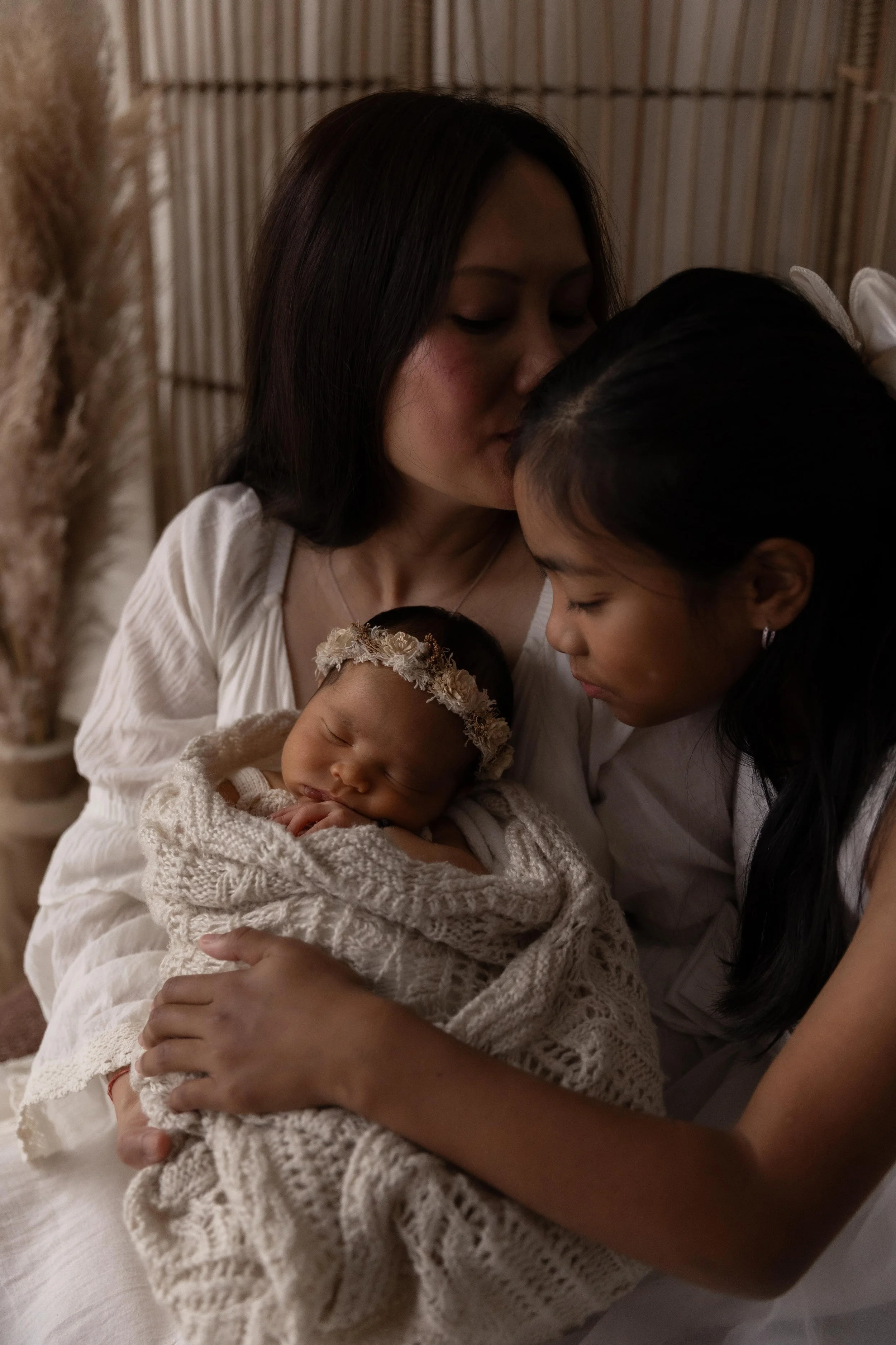 Connected family moment with parents and siblings welcoming their newborn baby during a slow, natural newborn photography session in Doreen.