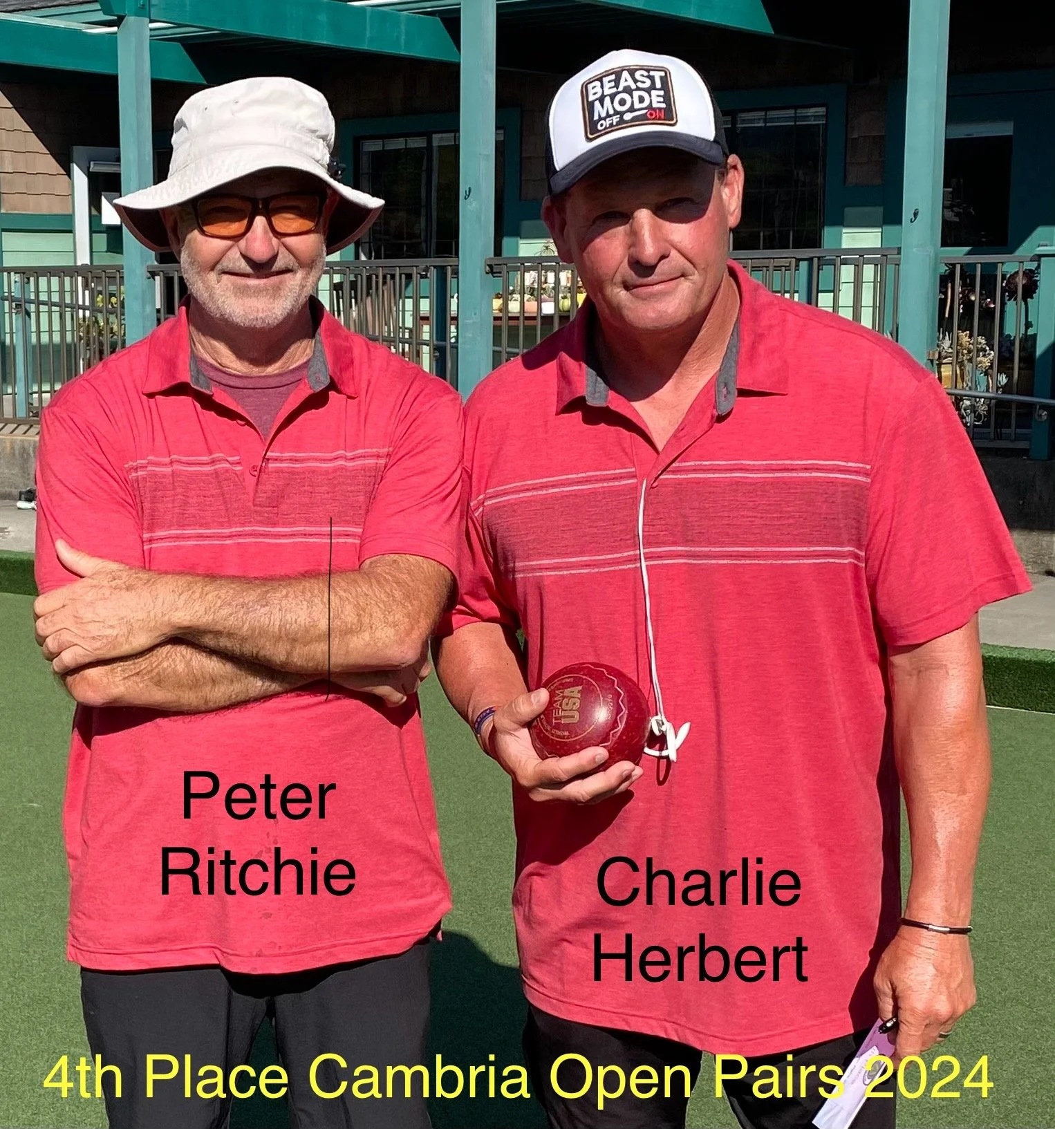 Two men in red shirts standing outdoors on a green lawn, with one holding a red trophy and the other with crossed arms, both smiling. The image has text indicating they took 4th place in the Cambria Open Pairs 2024. The man on the left is labeled Peter Ritchie, wearing glasses and a white hat, while the man on the right is Charlie Herbert, wearing a cap that says "Beast Mode".