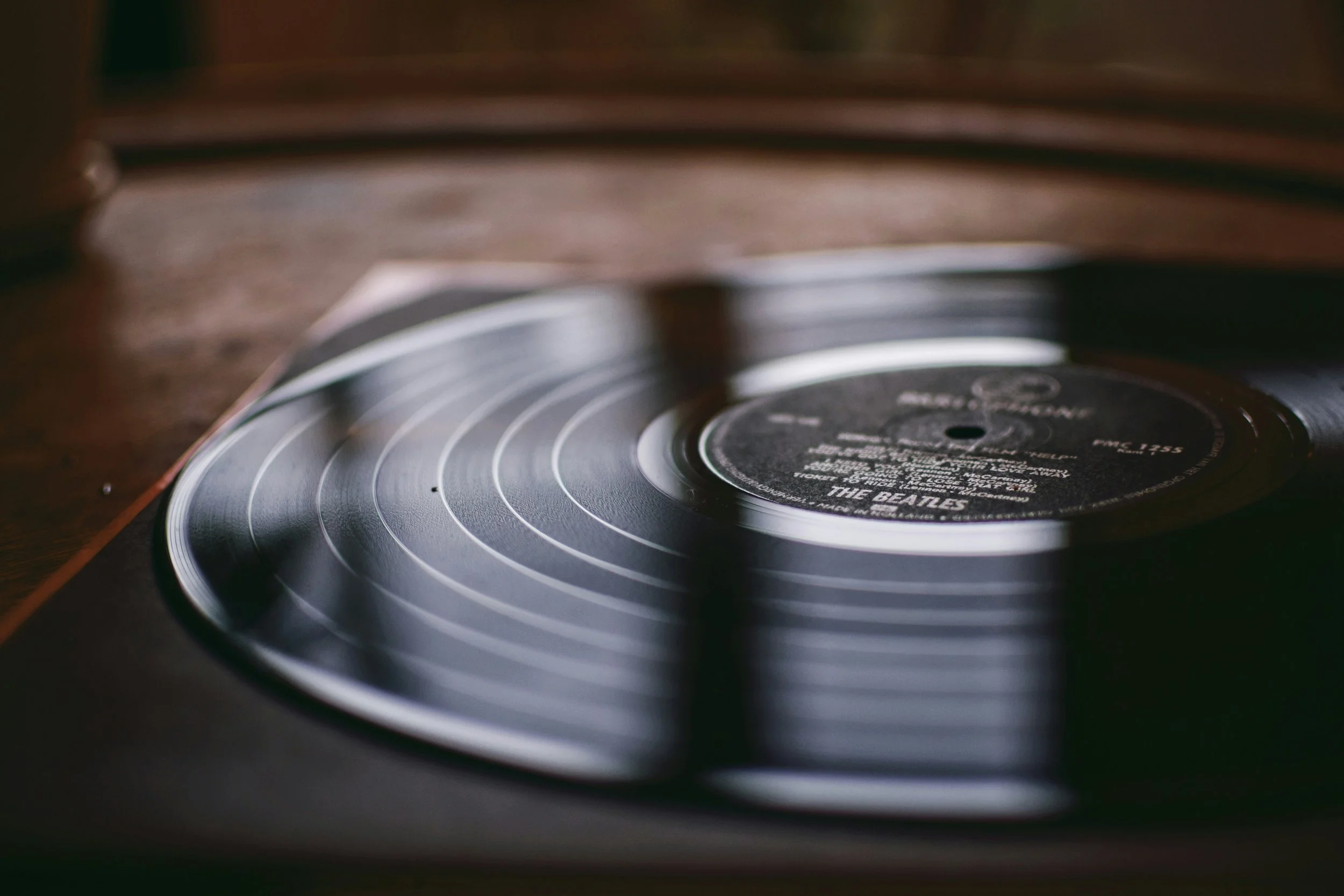 Close-up of a black vinyl record on a turntable with the label of The Beatles' album.