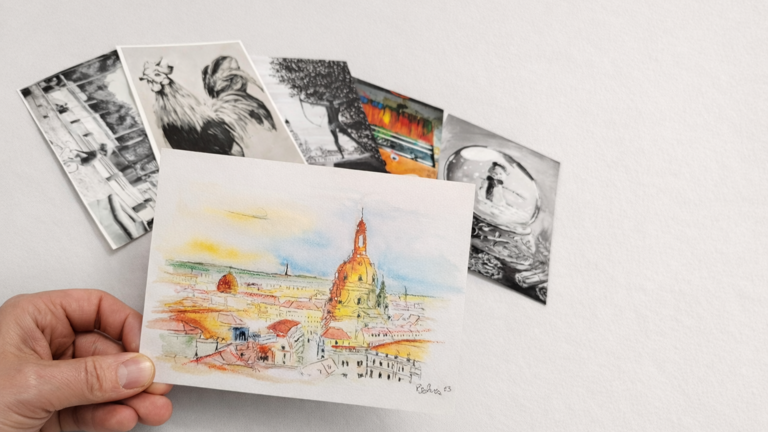 Hand mit verschiedenen Postkarten von Ricardo Schwarz