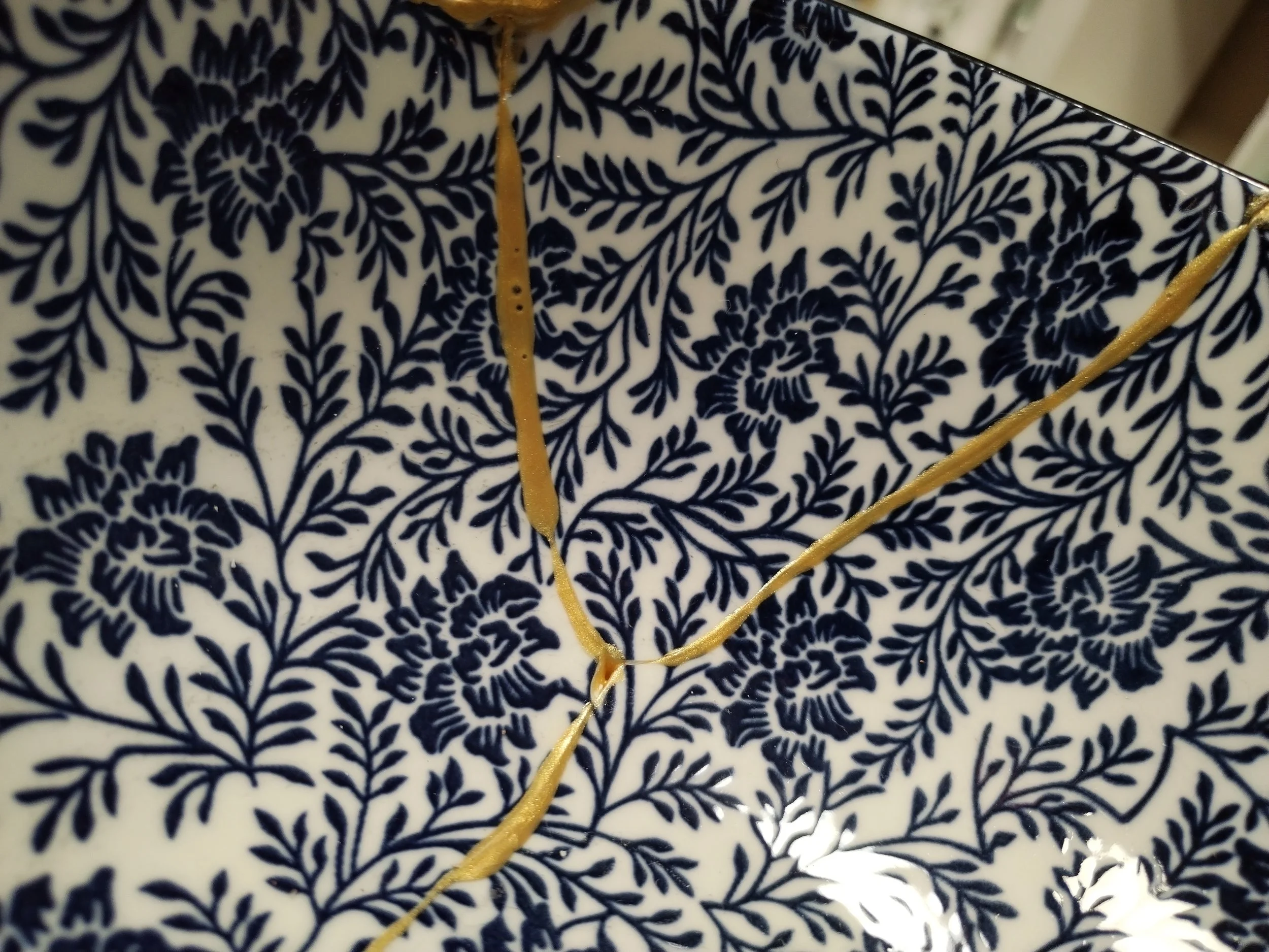 Detailaufnahme einer blauweiß gemusterten schale die mit der Kintsugitechnik repariert wurde
