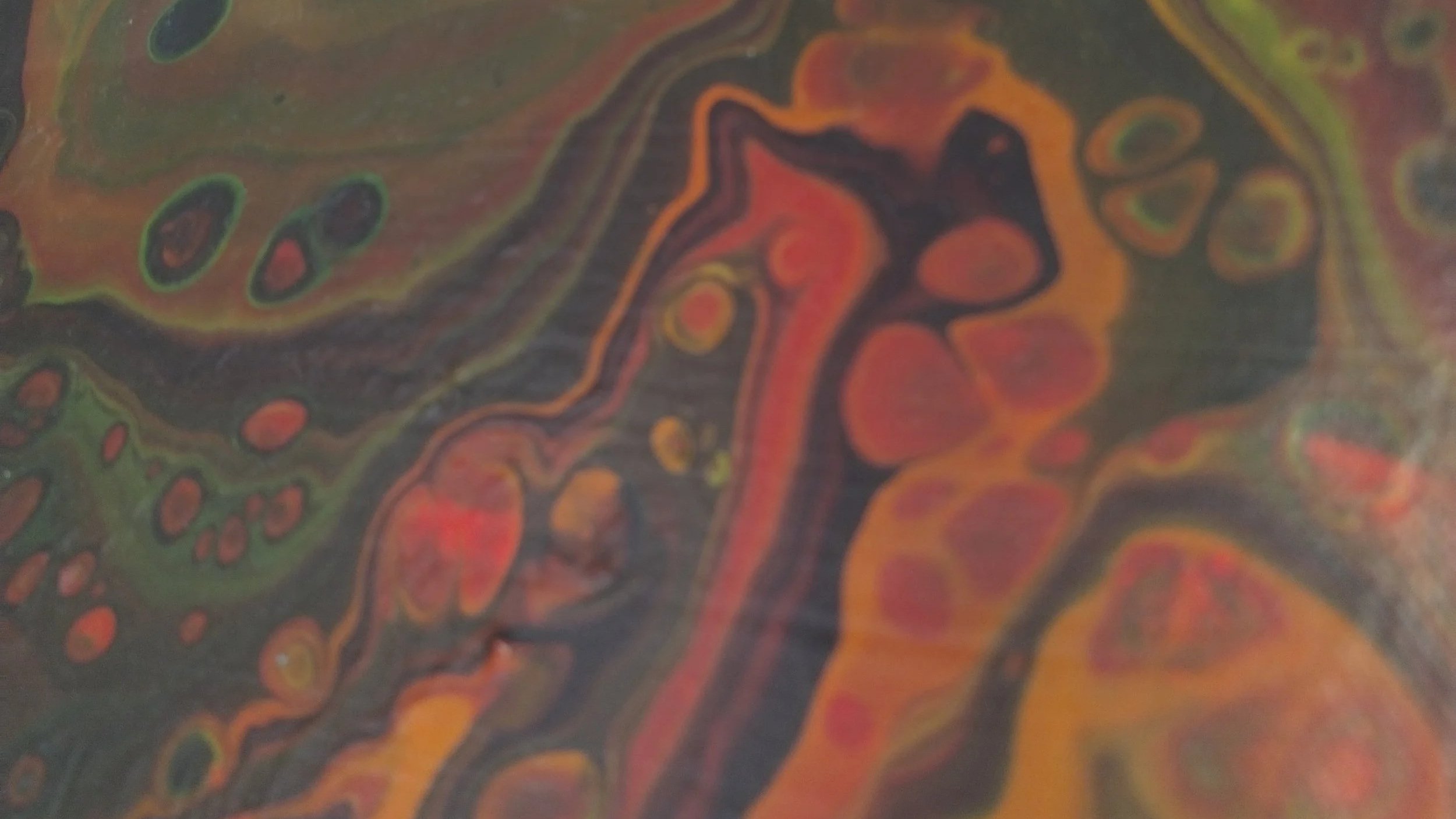 Detailaufnahme eines Pouringbildes in Rot und Orangetönen