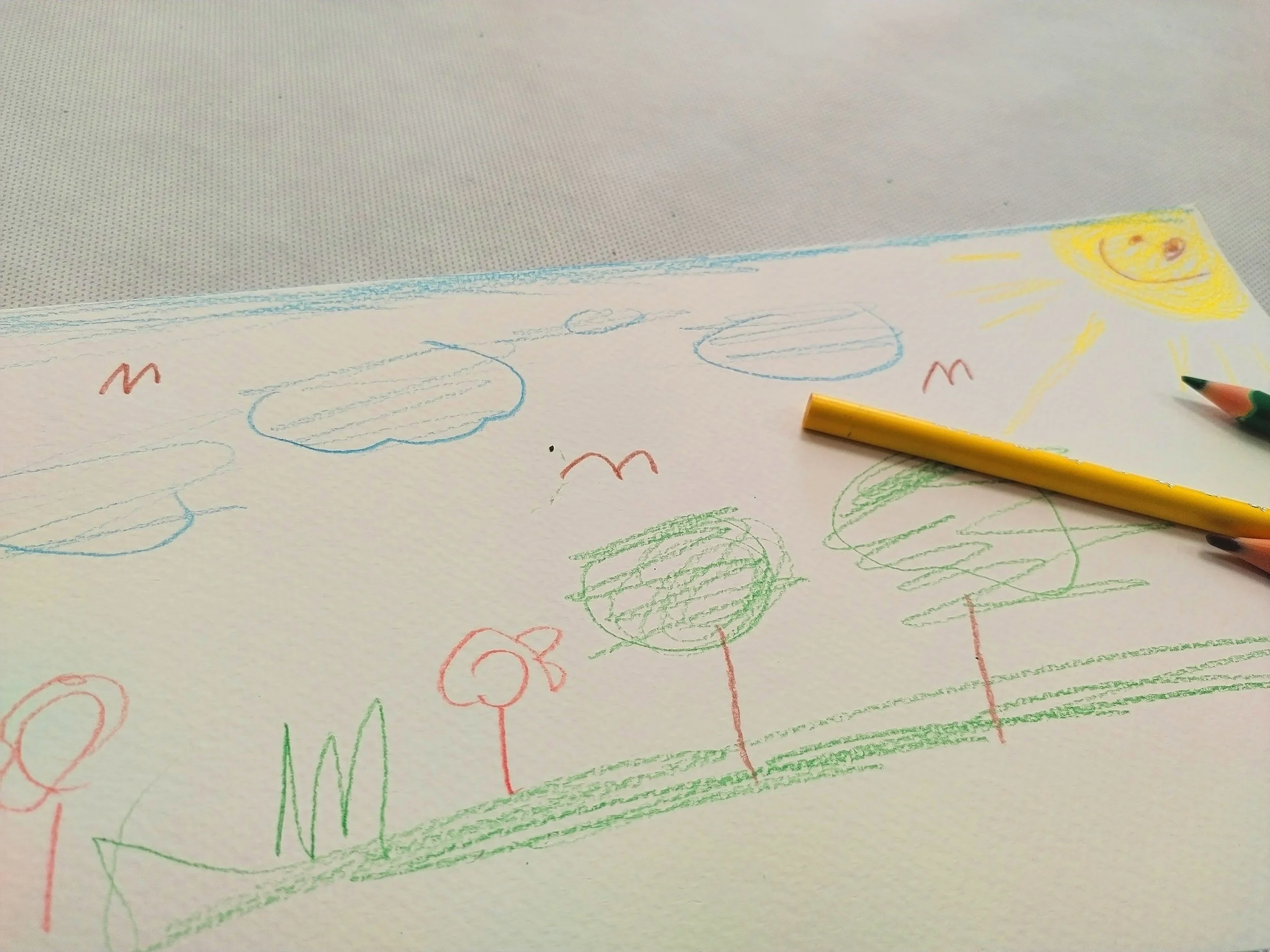 Kinderzeichnung mit Sonne oben rechts im Bild