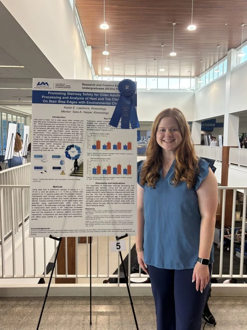 Karah Lawrence standing beside her RCEU research poster on stairway safety, with a first place ribbon pinned to it.