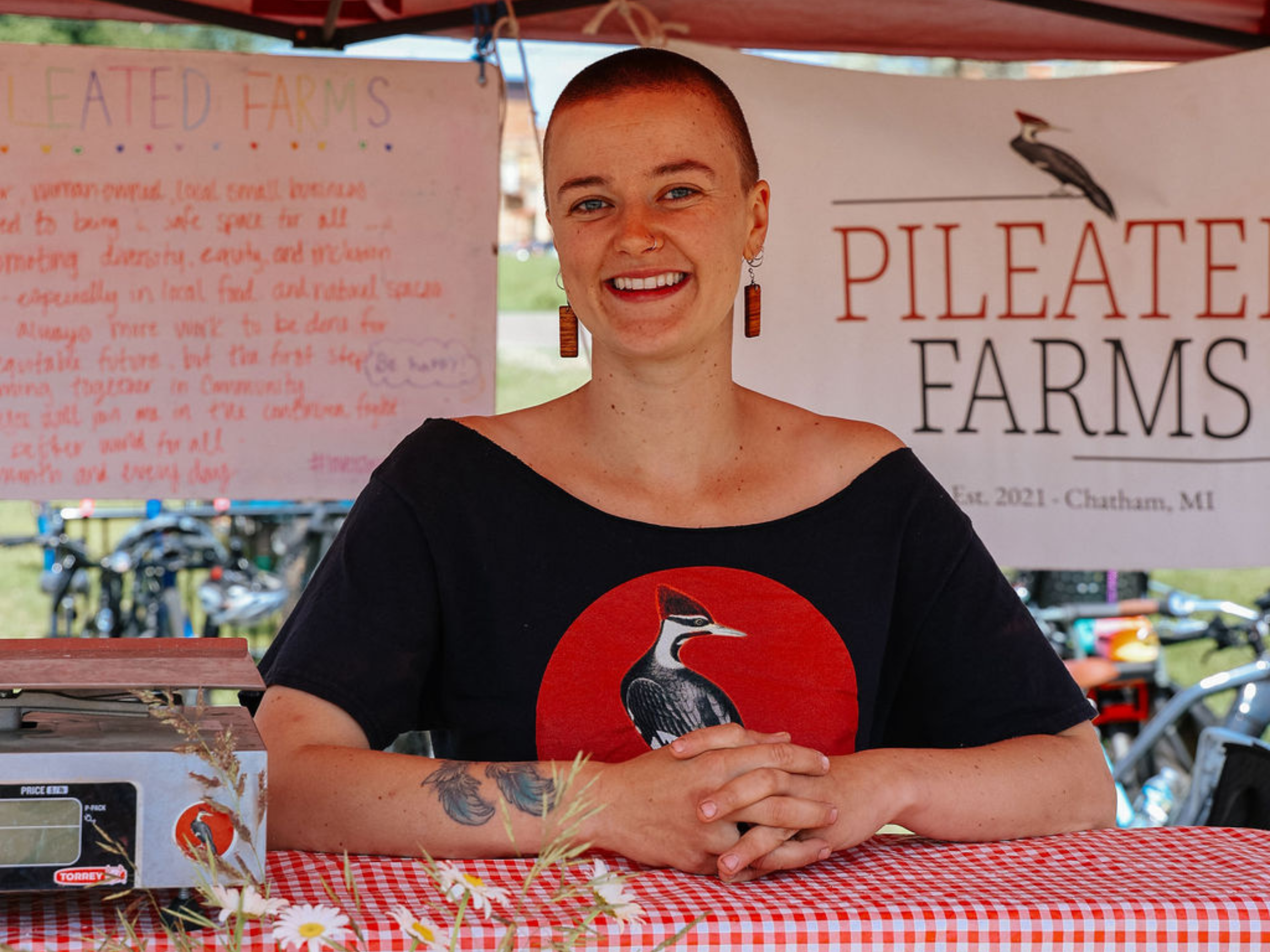 Olivia from Pileated Farms in the market stand.