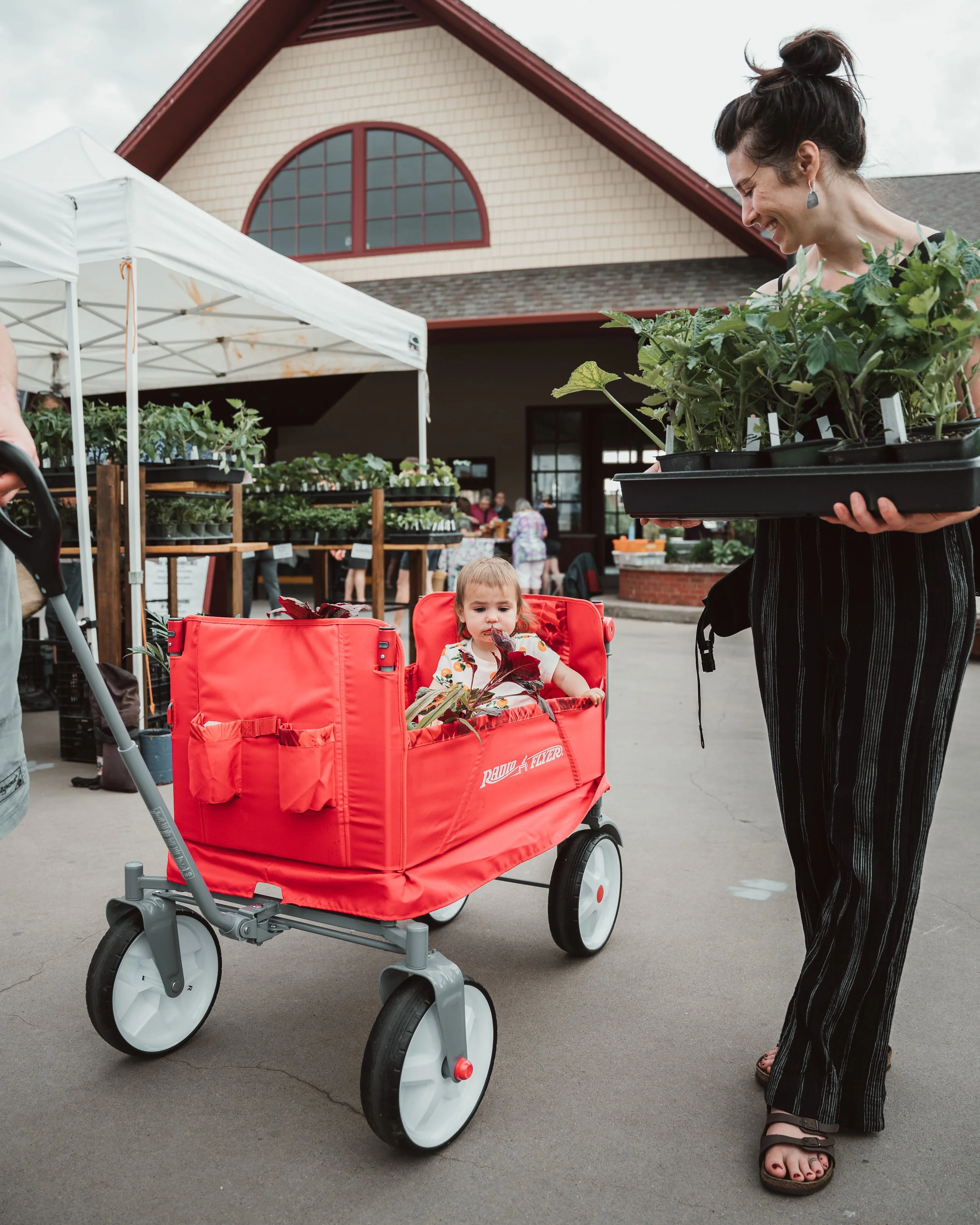 Parents pulling child and market goods in a wagon