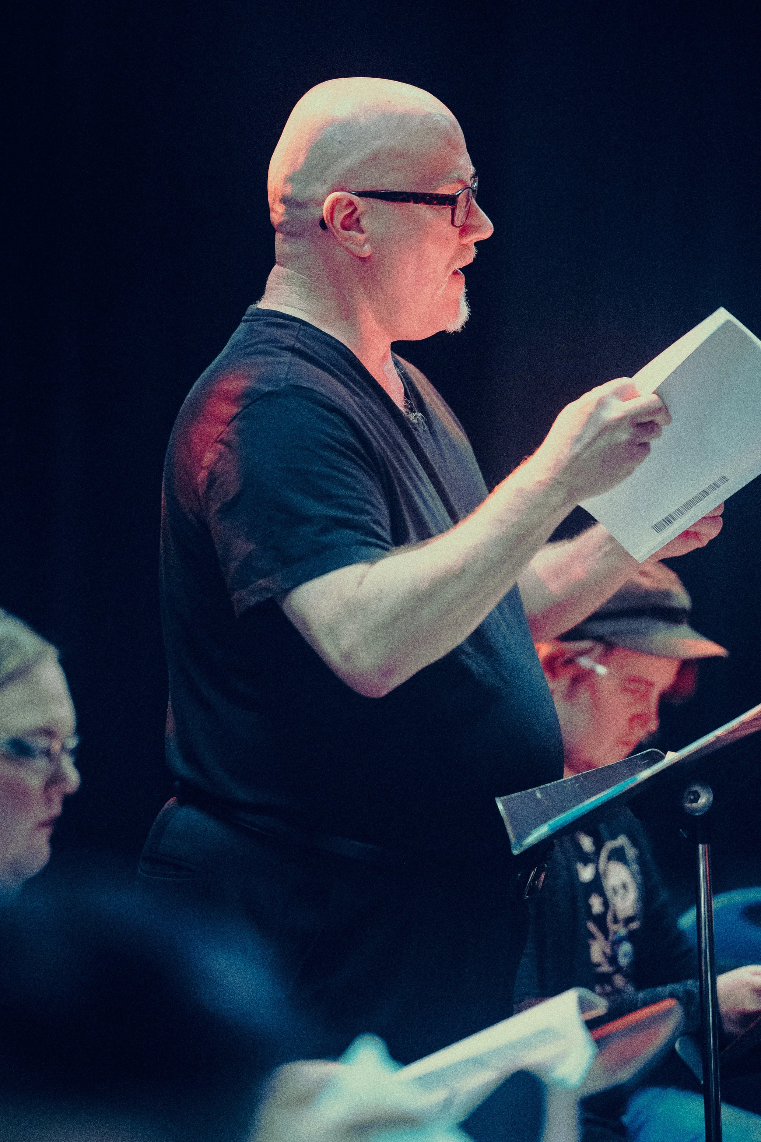 Man with glasses reading script