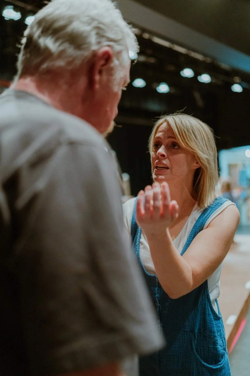 Two people engaged in a conversation on stage, with one appearing animated or expressive.