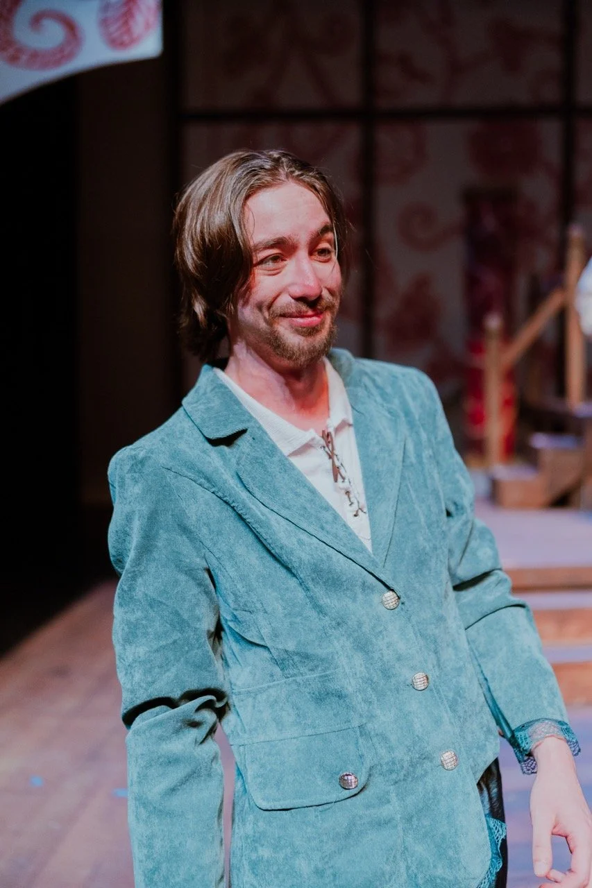 Man in a teal jacket on stage