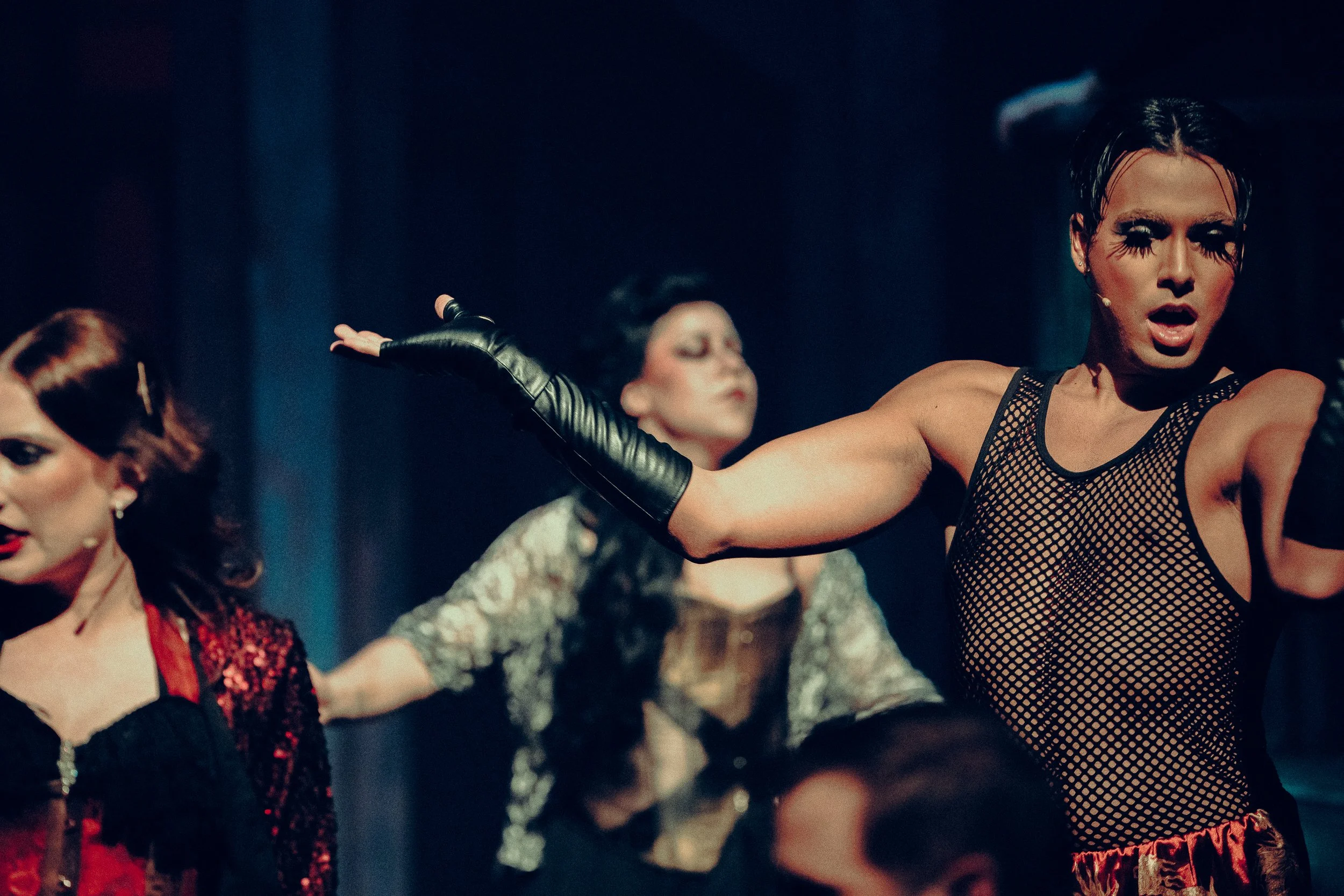 Theatrical performance with performers in costume, featuring dramatic makeup and expressive gestures.