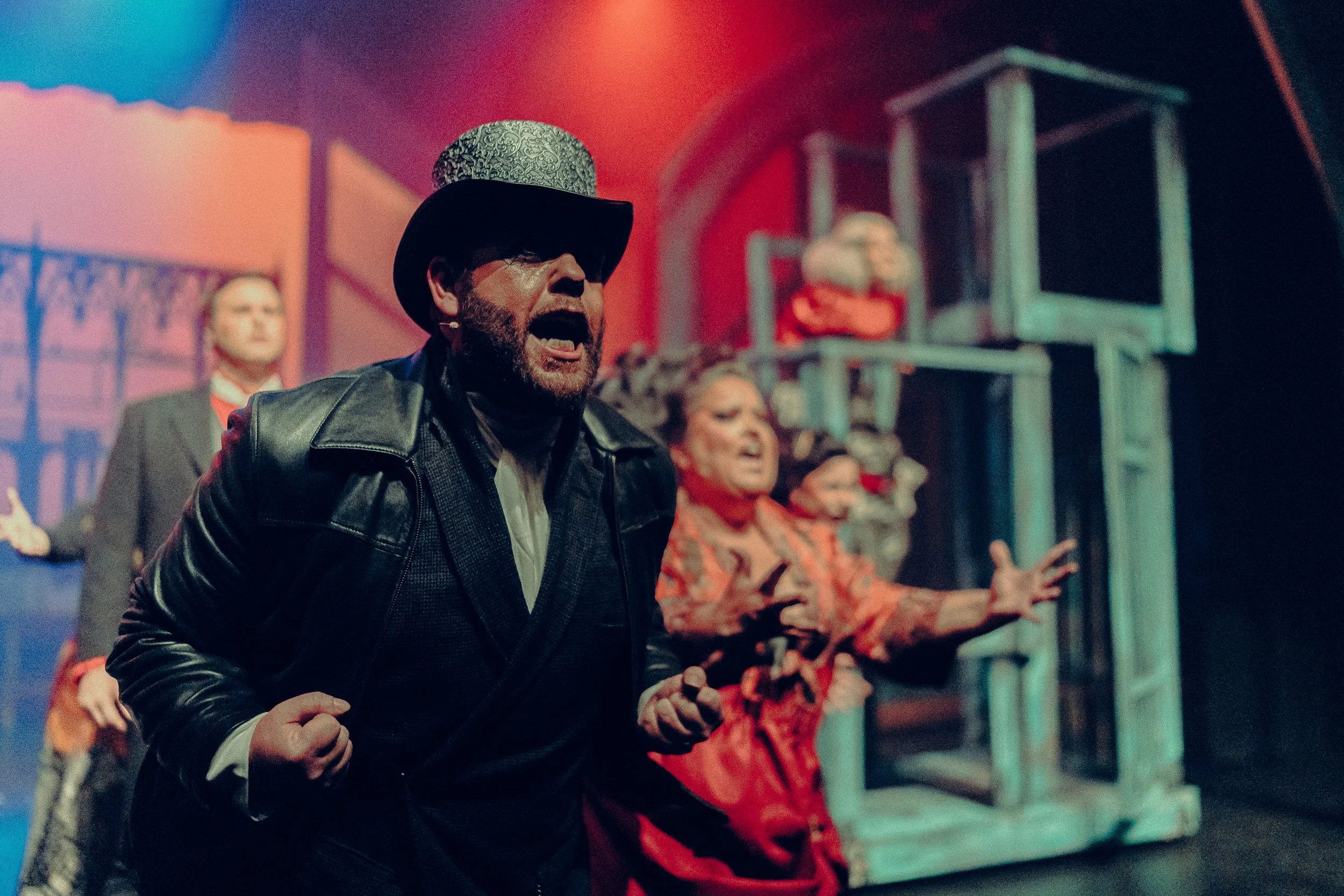 Theater performance with actors in dramatic costumes singing on stage