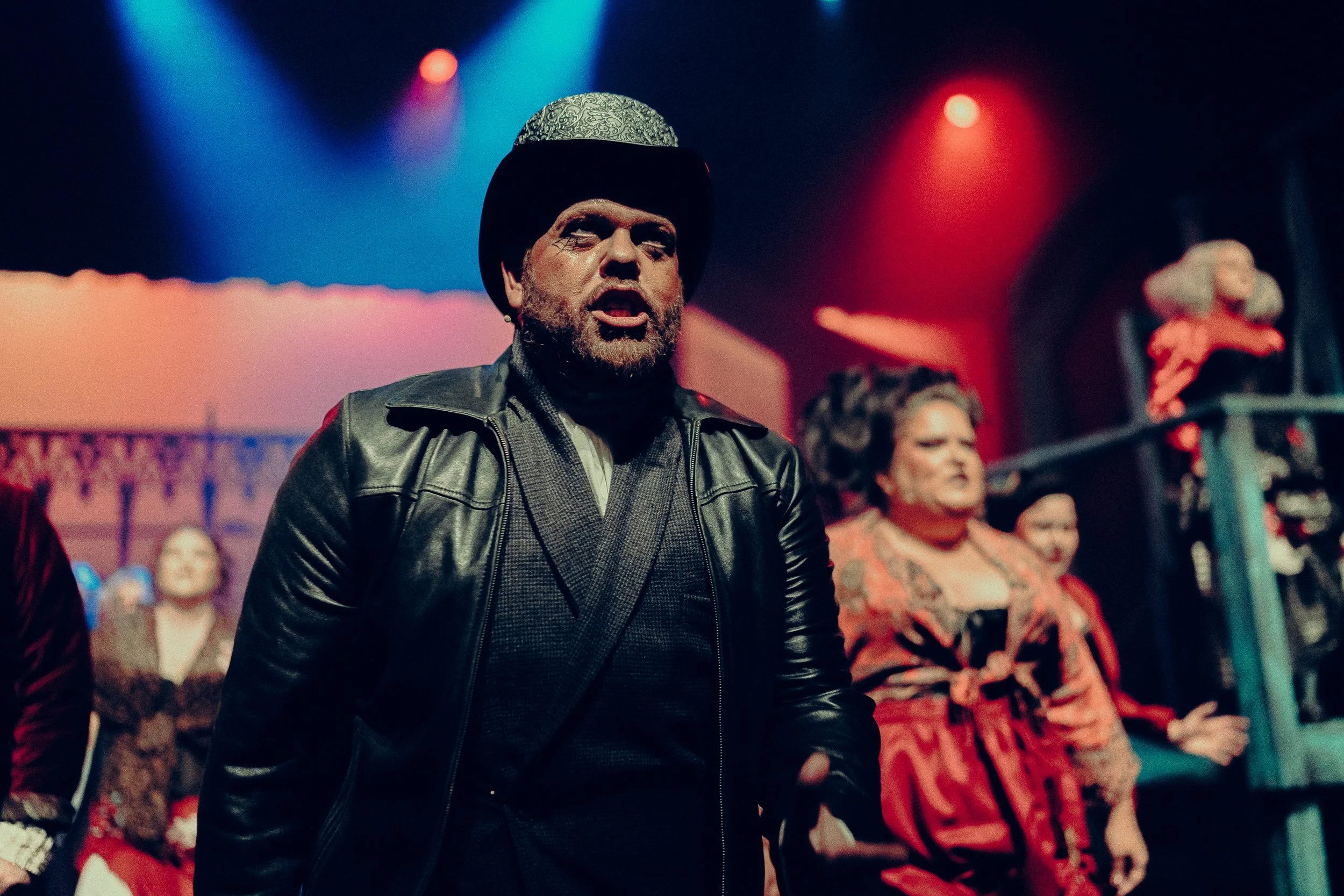 Theatre actors performing on stage with colorful lighting and costumes