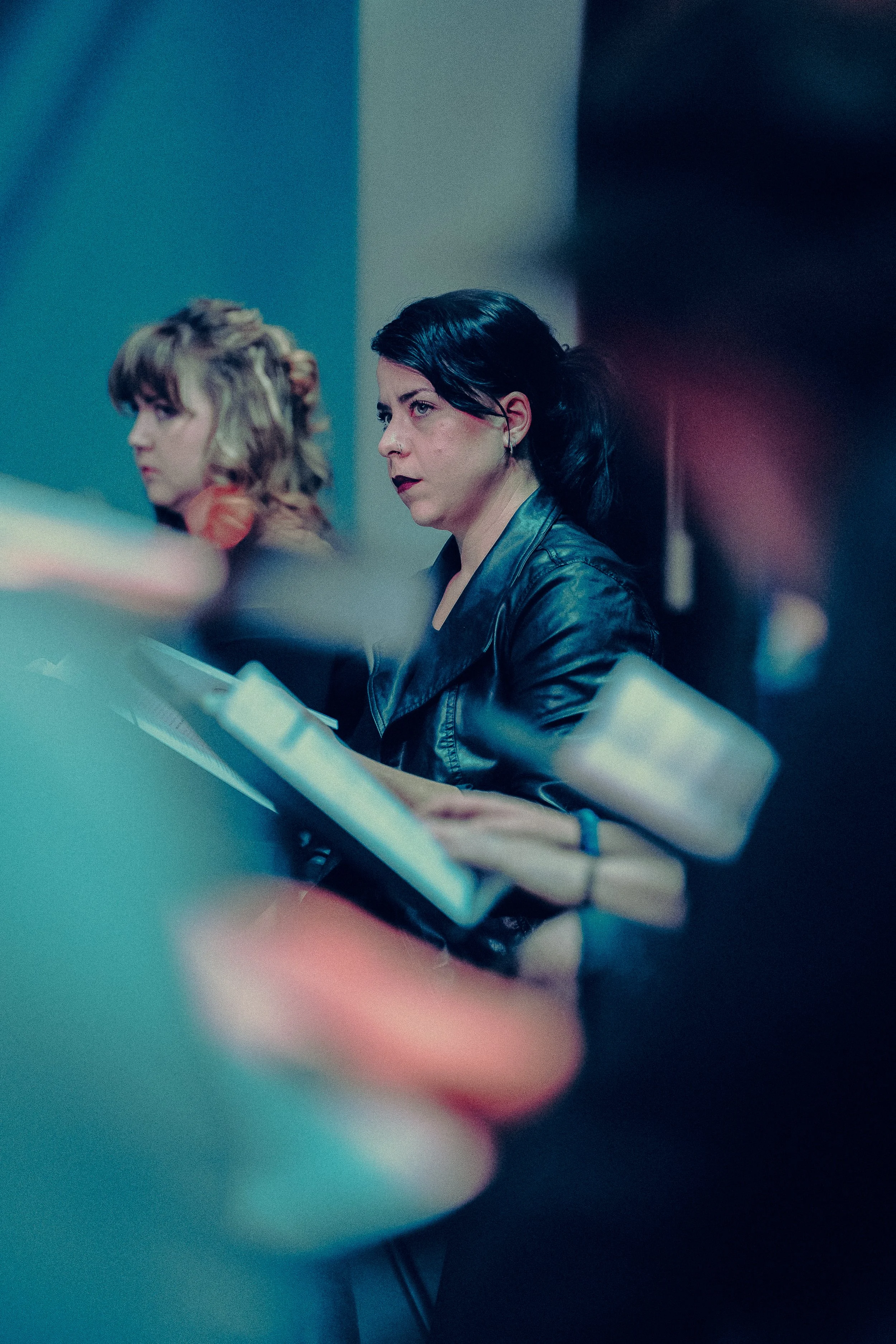 Two women holding scripts in a rehearsal setting.