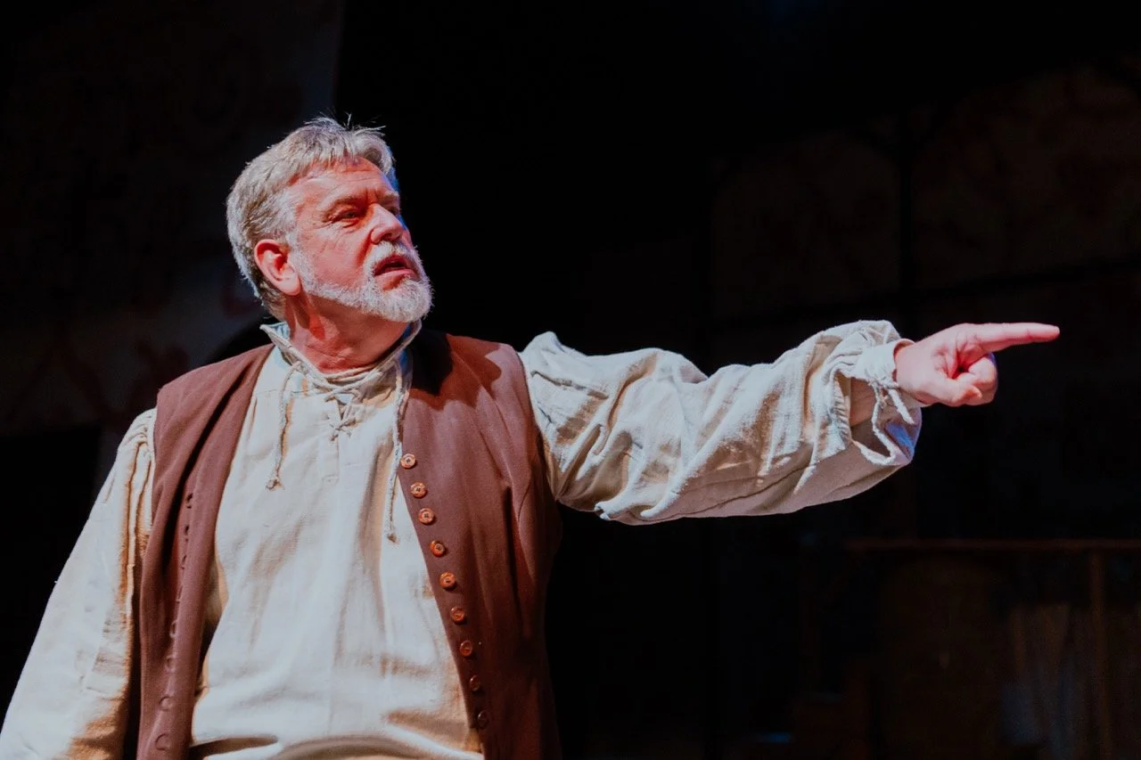 Actor in period costume pointing dramatically on stage