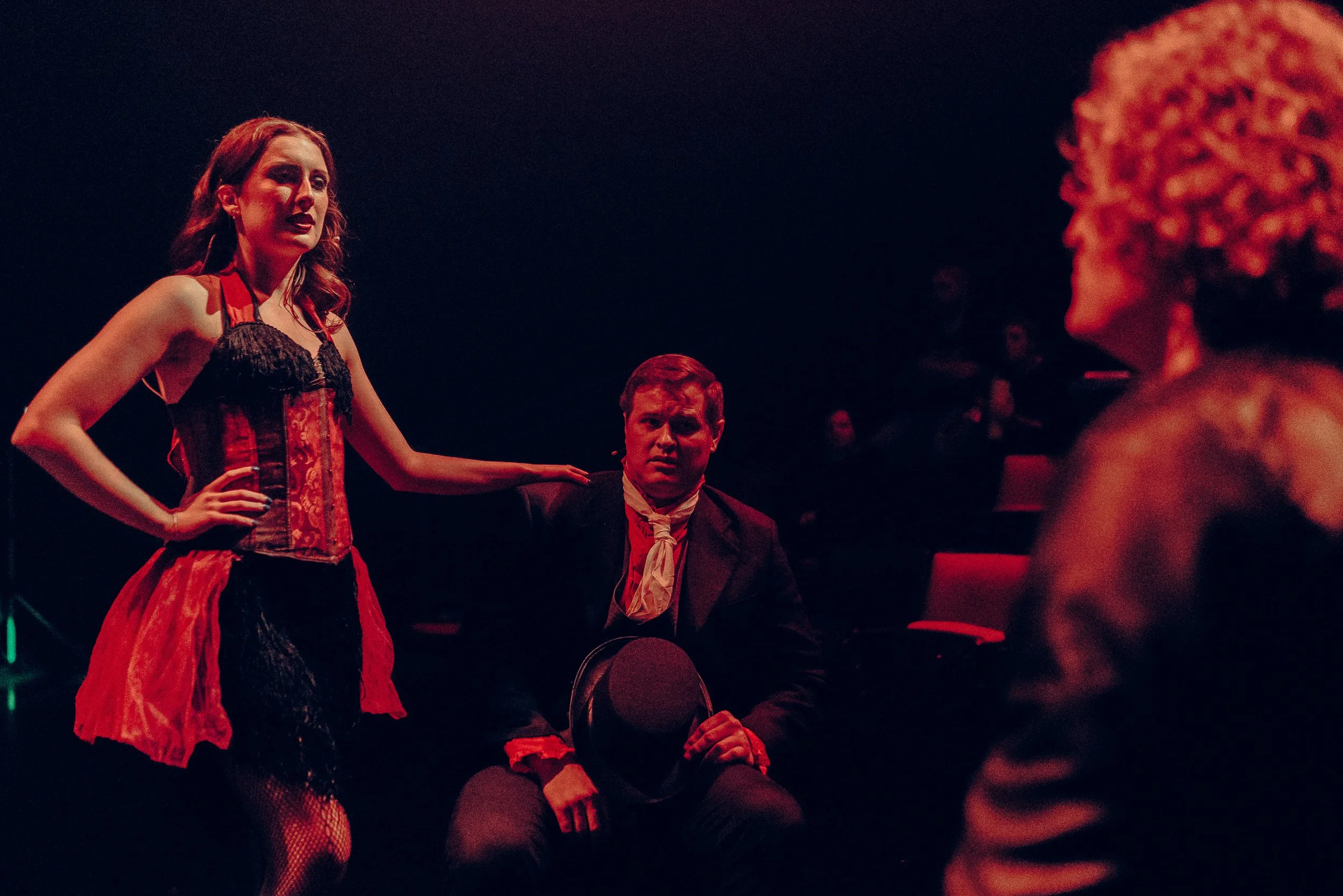 Theatrical performance with male and female actors in dramatic lighting