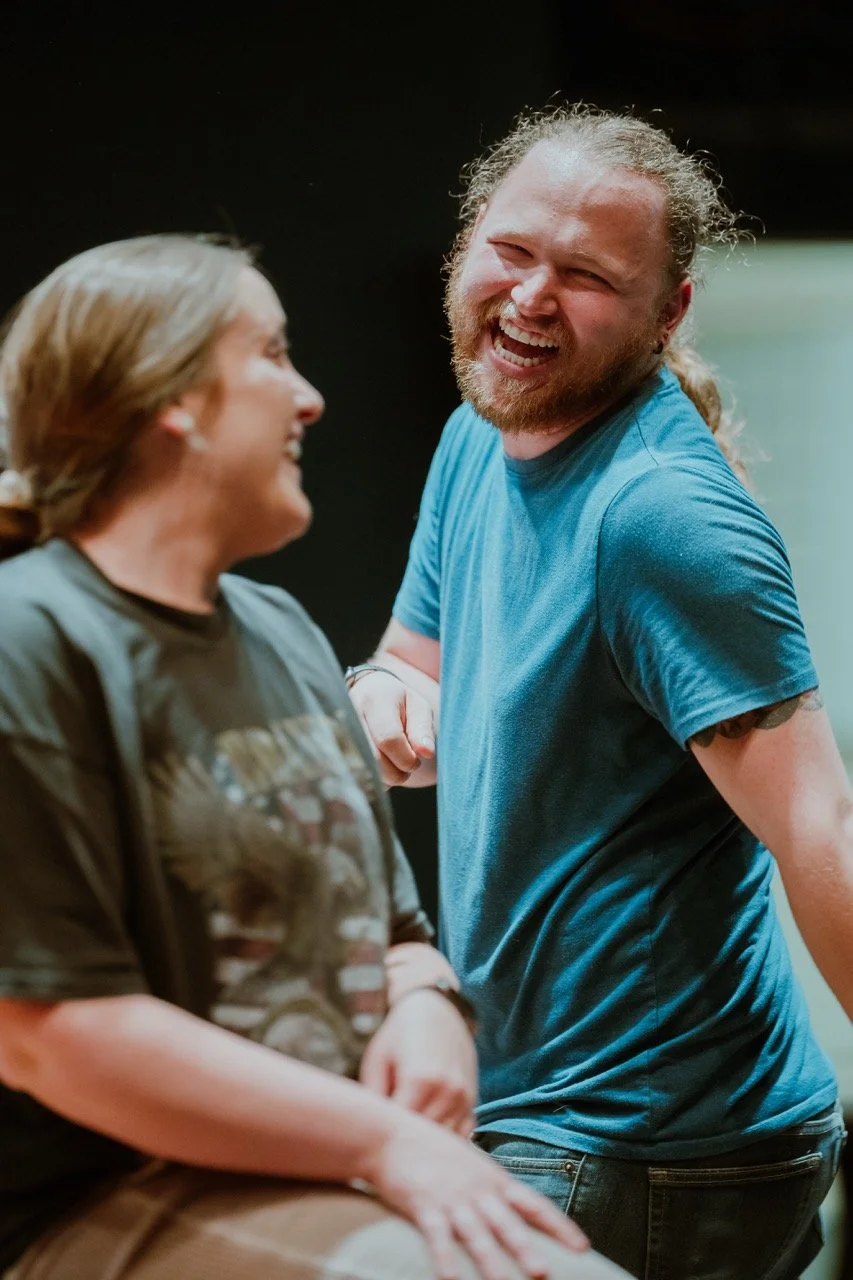 Two people smiling and laughing together in a casual setting.