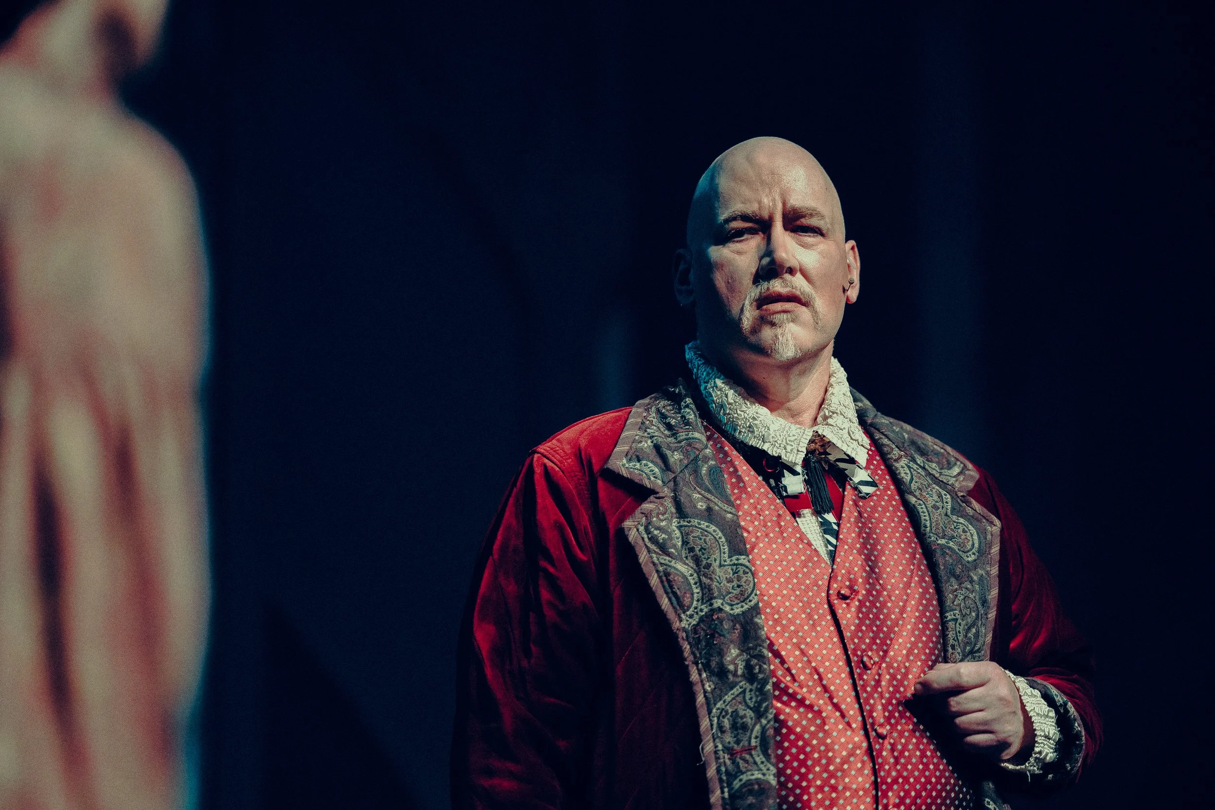 Man in ornate period costume on stage