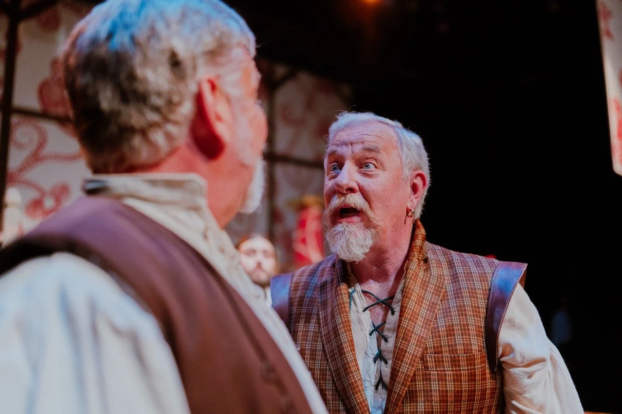 Two actors in a dramatic scene during a theater performance, one with an expressive face.