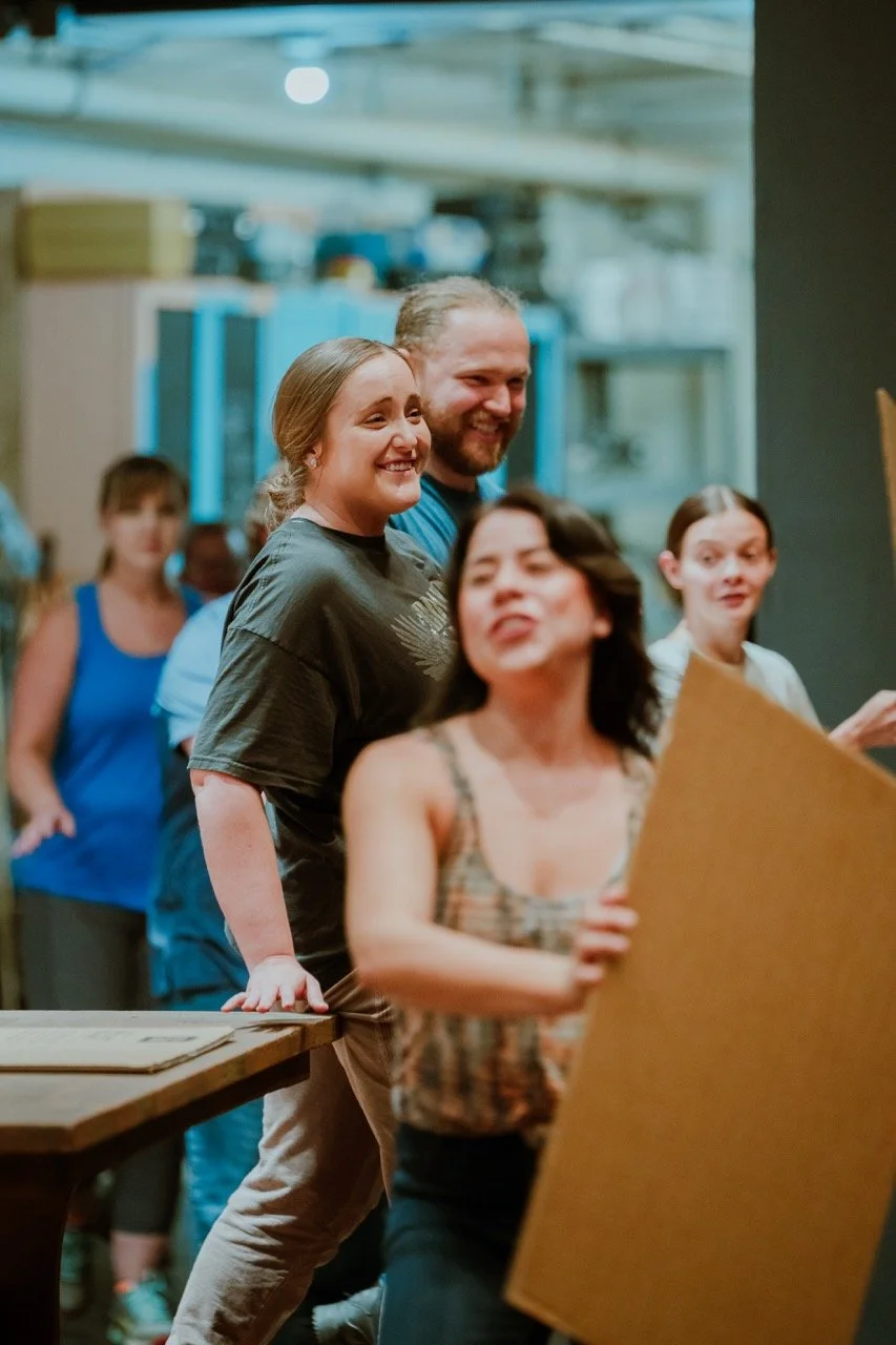 Group of people laughing and interacting in an informal indoor setting.