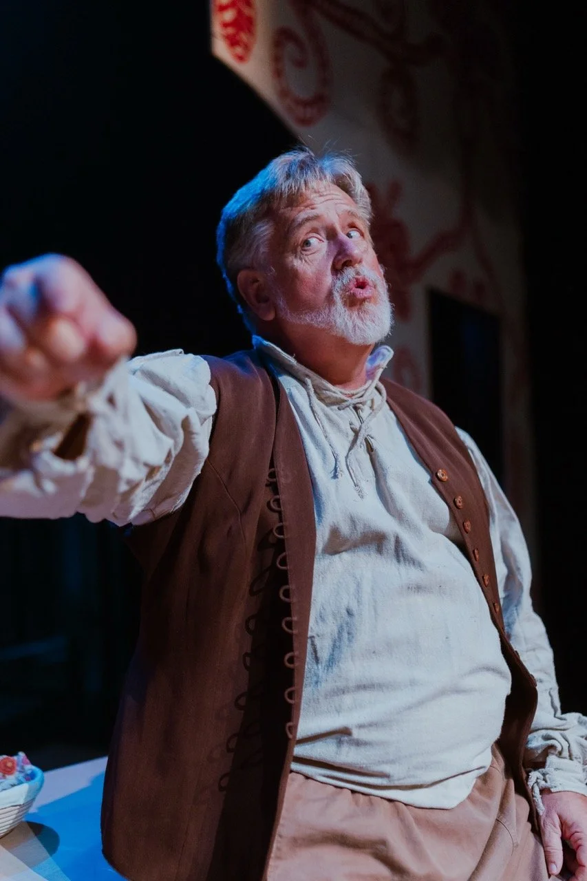 Elderly man performing on stage in historical costume