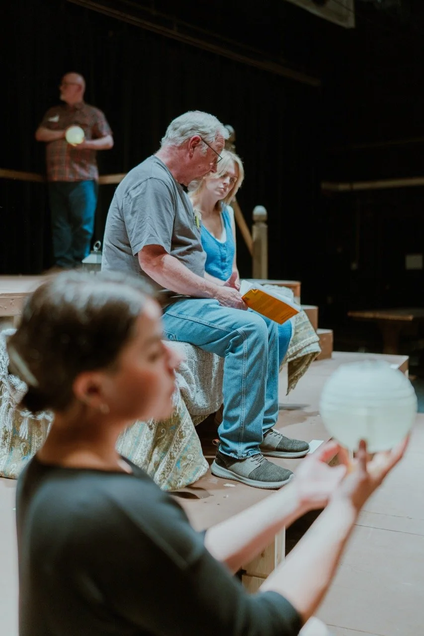 Theater rehearsal with actors holding props