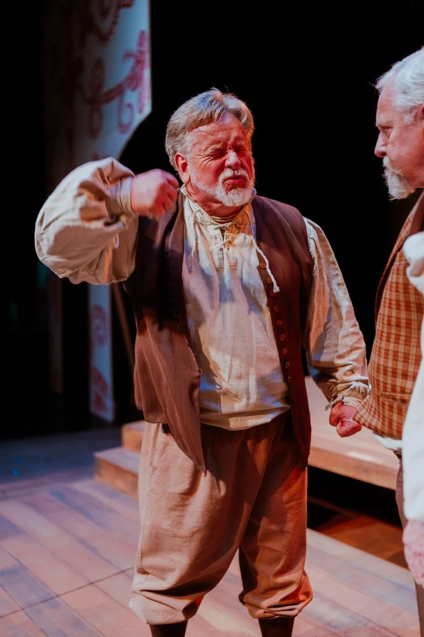 Two men in period costumes performing on stage