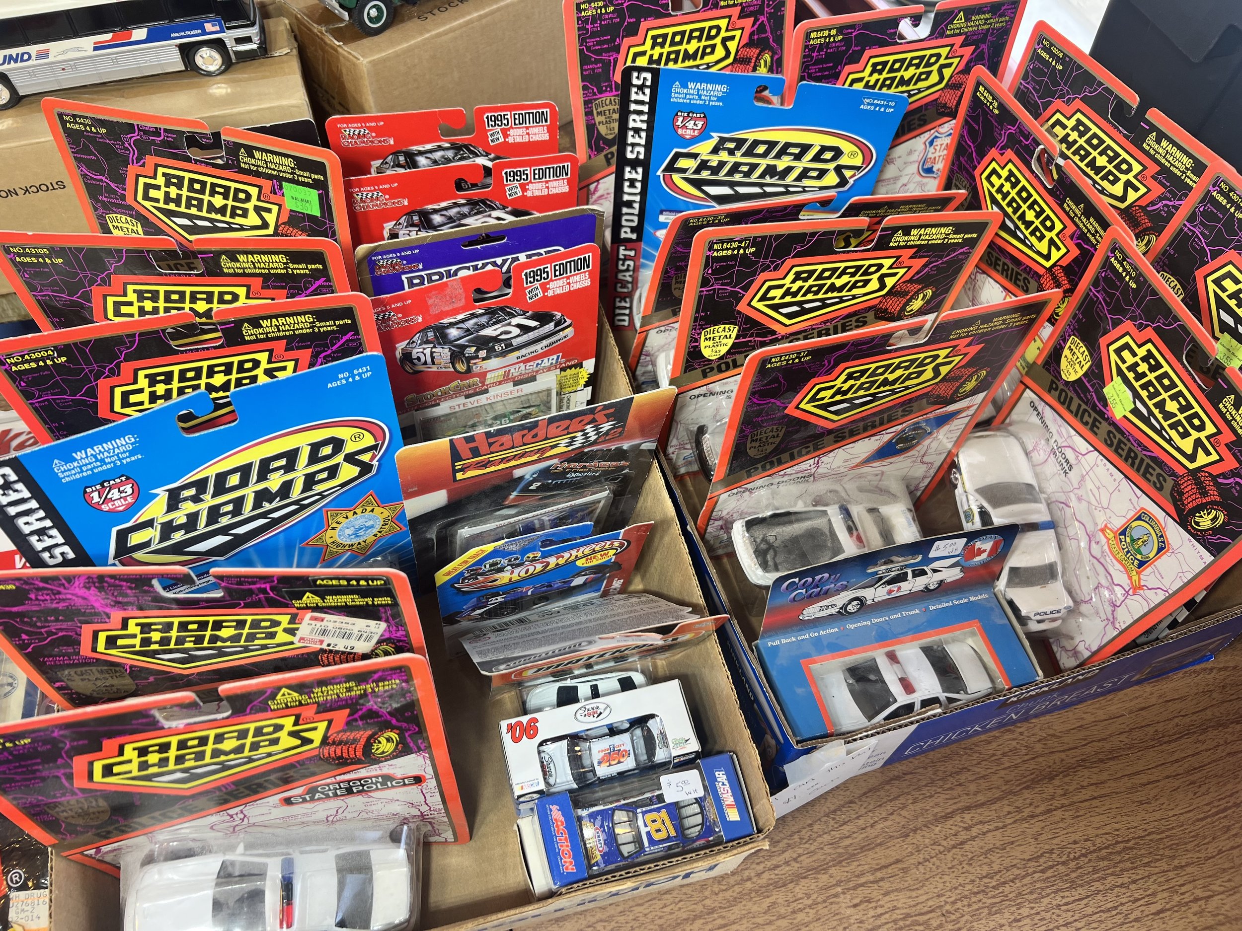A massive collection of vintage 1:43 scale die-cast metal Road Champs Police Series vehicles, including various state and local patrol liveries, many still in their original 1990s packaging