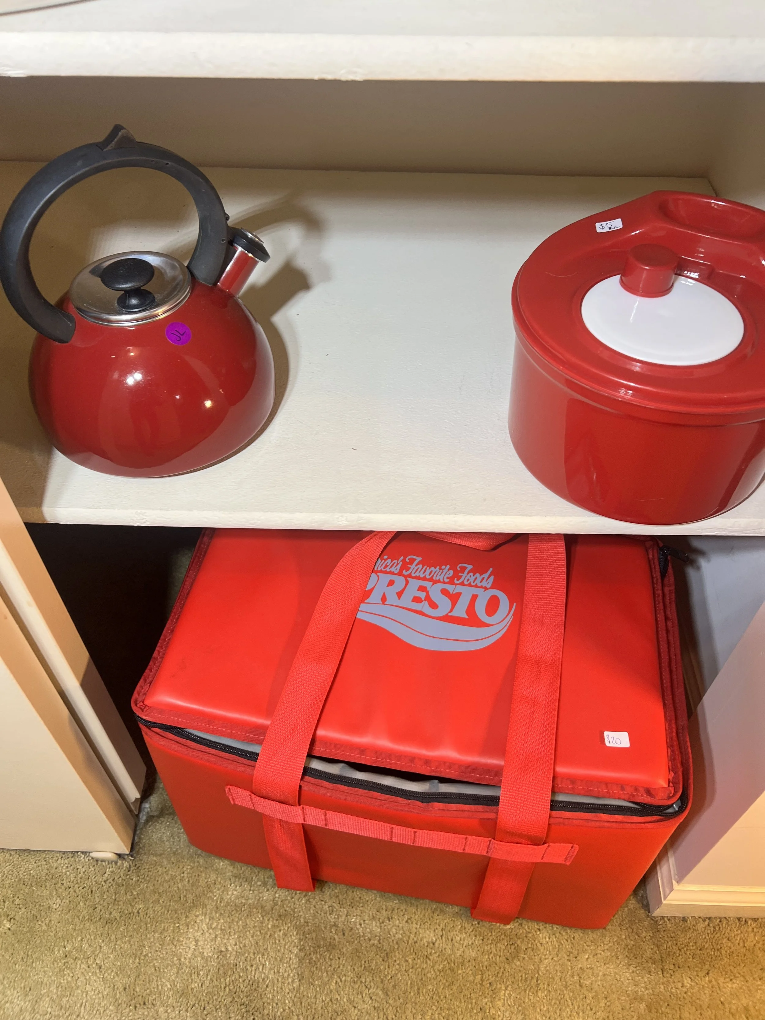 A red enamel tea kettle and a Presto insulated food carrier