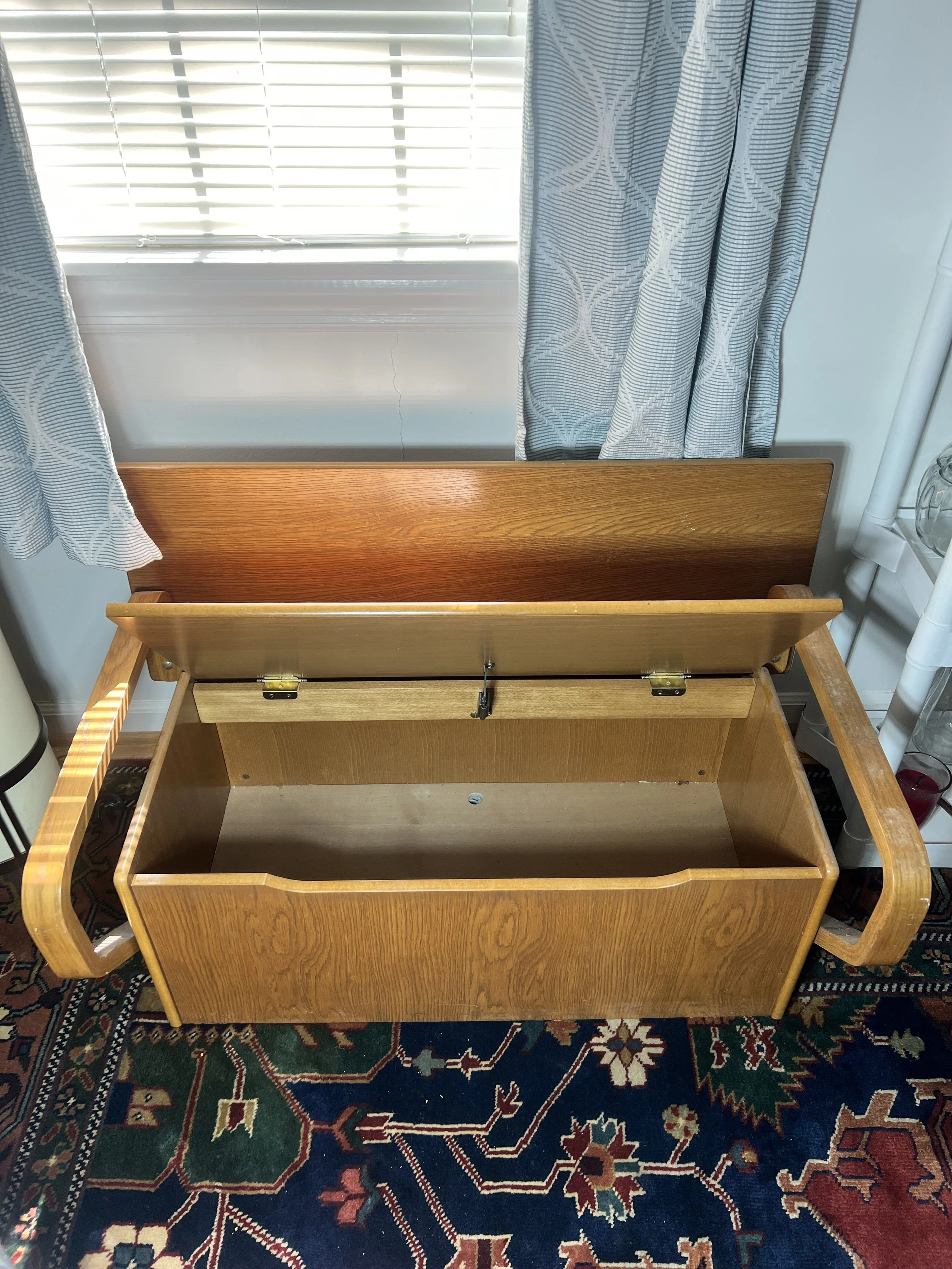 Mid-century style wooden storage bench featuring unique curved bentwood armrests and a flip-top storage seat